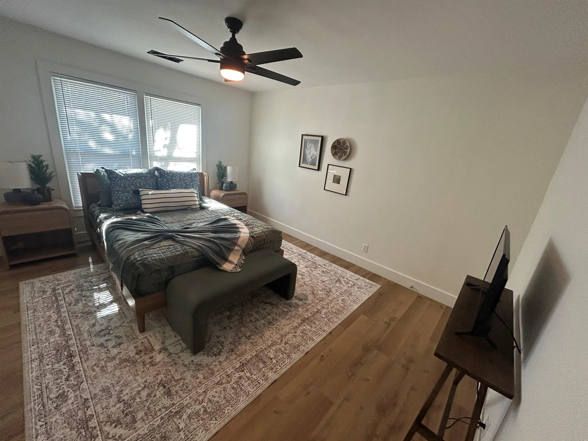 A bedroom with a bed, dresser, and nightstand.