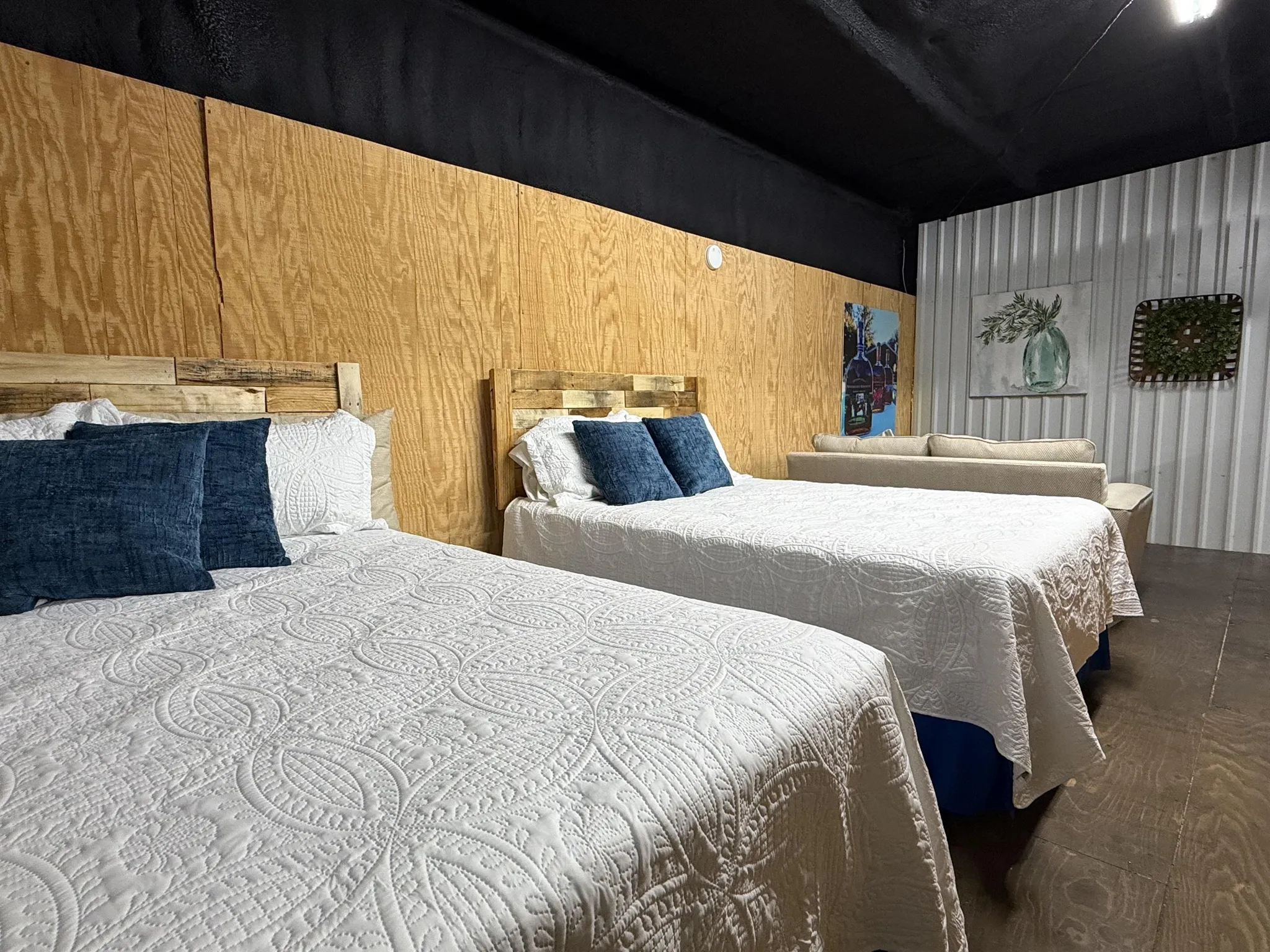A rustic dining room features a wooden table set for dinner with wine and snacks.