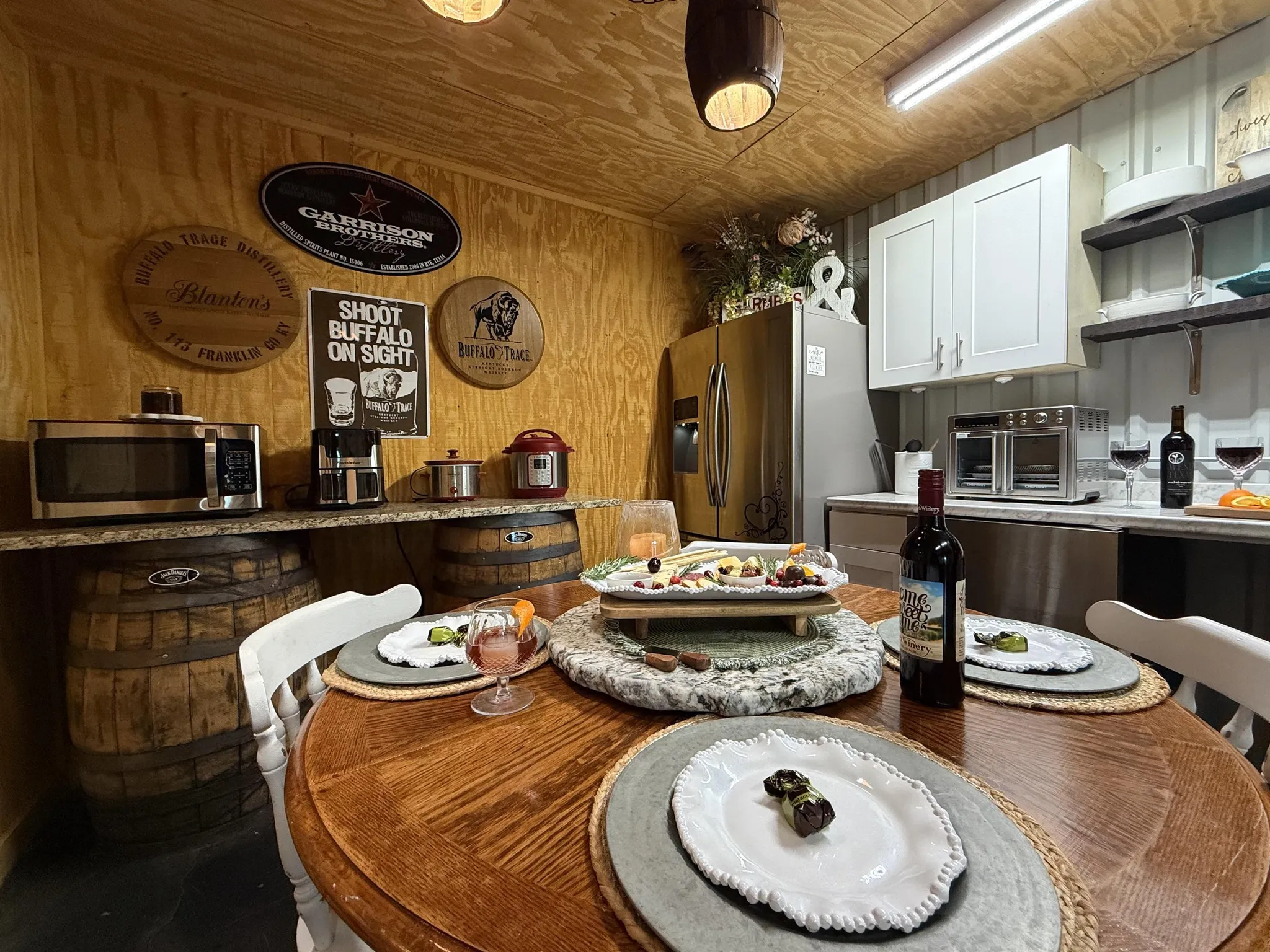 Rustic building exterior with outdoor seating, heaters, and double doors.