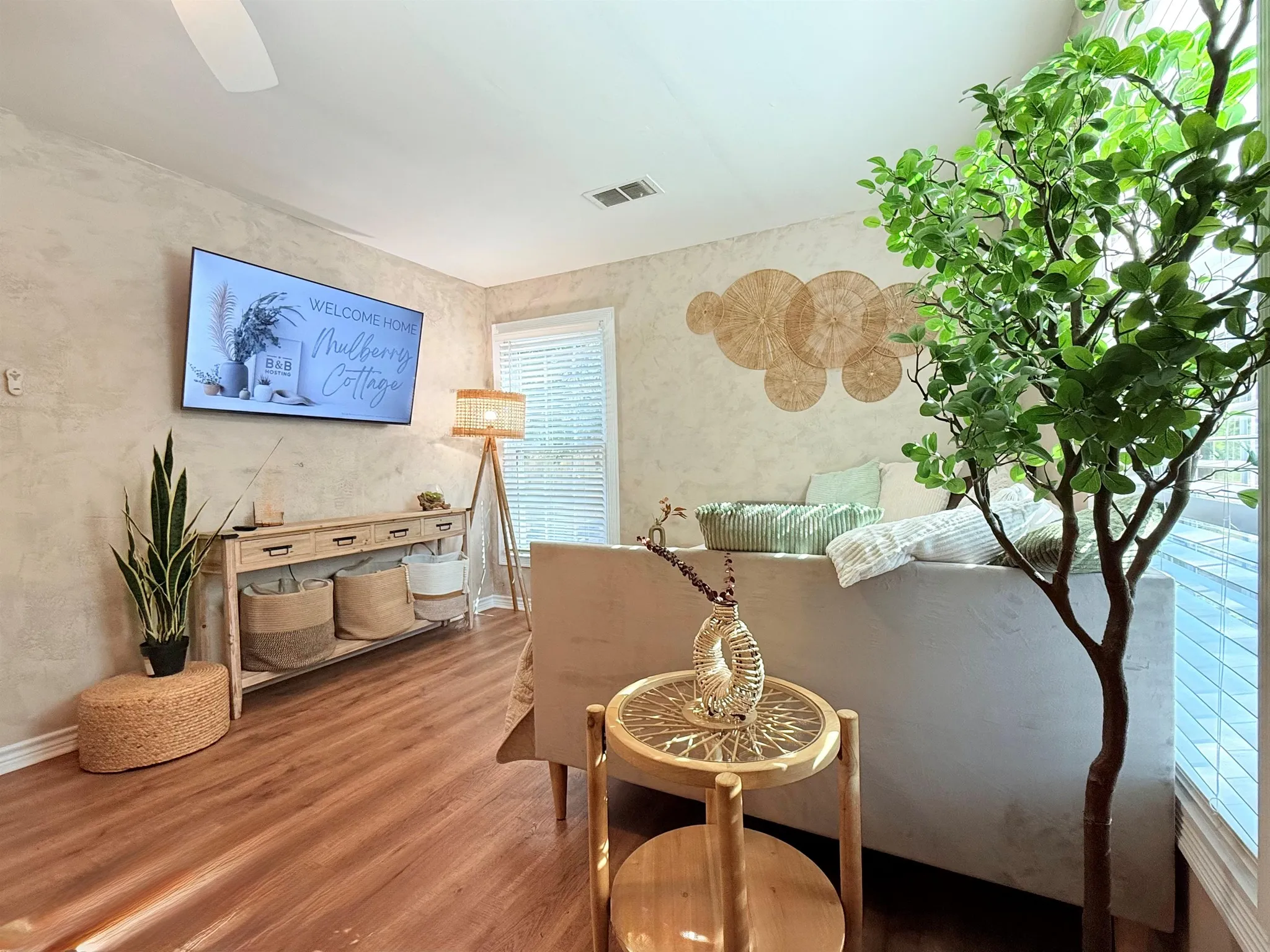 A cozy living room with a sofa, a TV, a lamp, and decorative items.