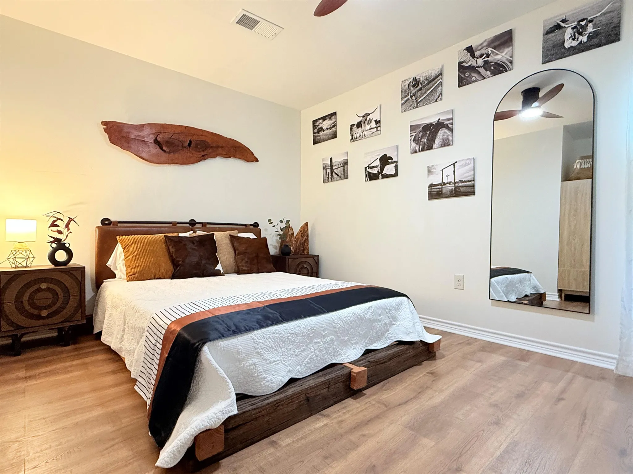 A king-sized bed with a rustic wooden frame and dark-toned bedding is the focal point of this bedroo