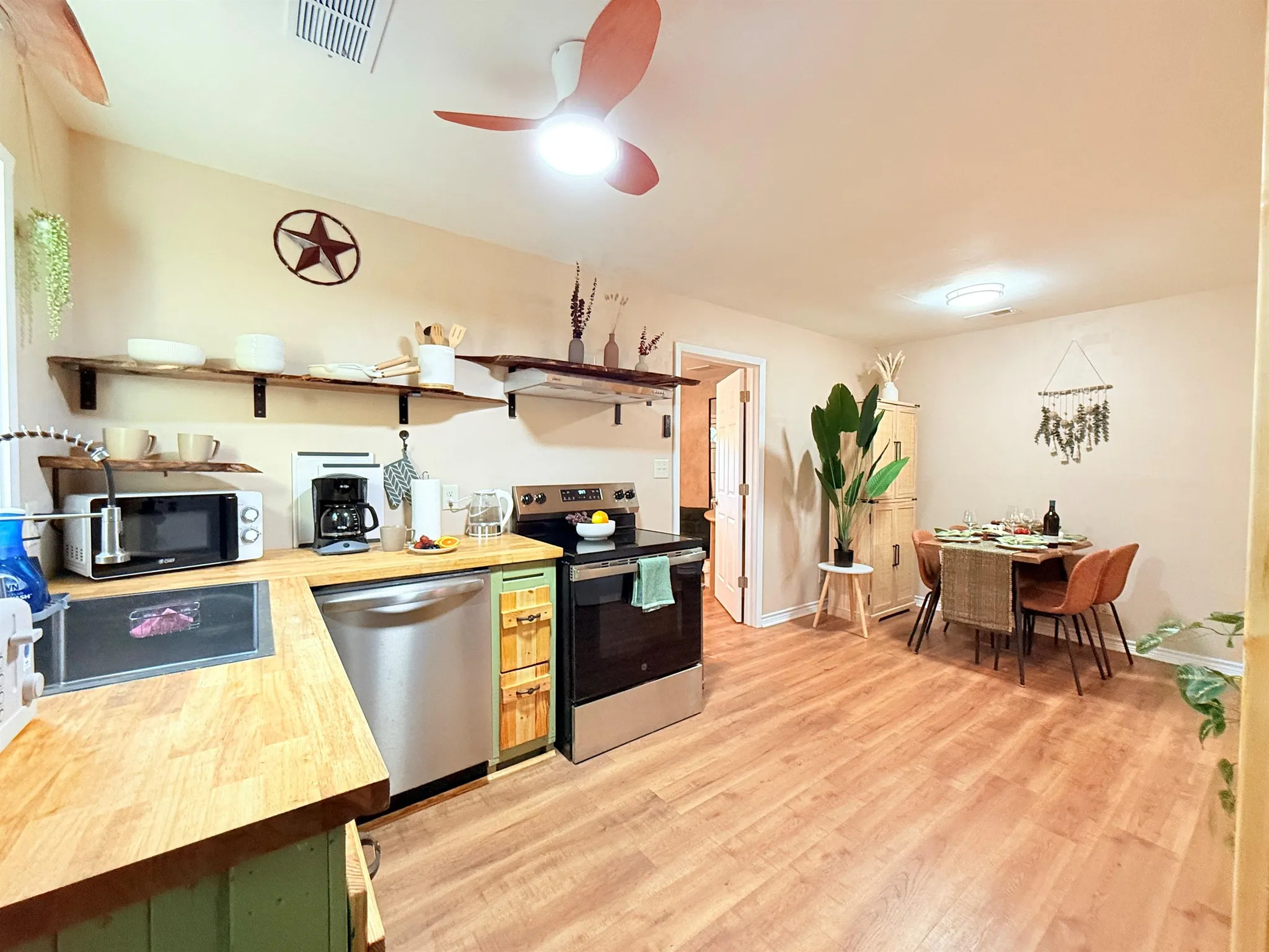 A kitchen and dining area with a wooden floor, table, and chairs.