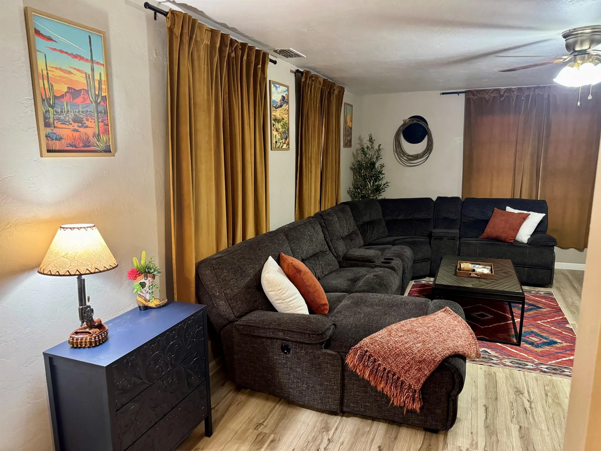 Interior view of a kitchen and living room with blue couches.