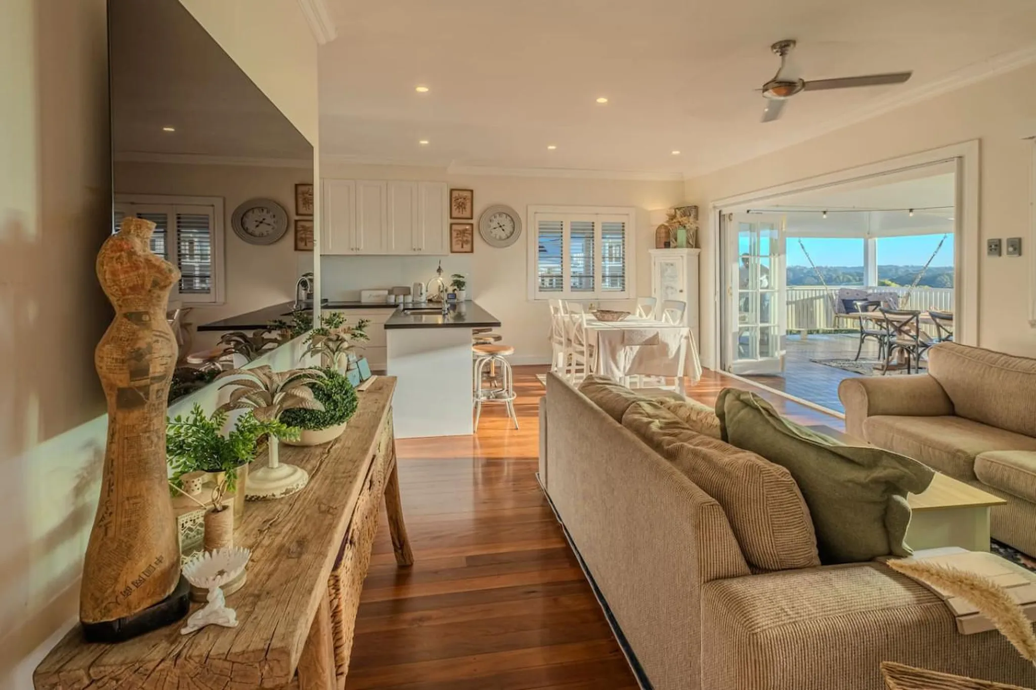 Living room with kitchen, dining area, and outdoor patio with a view.