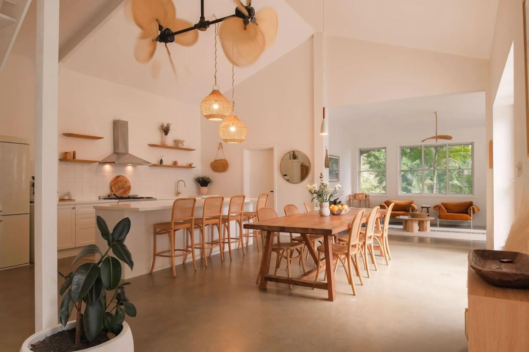 A modern, open-plan kitchen and dining area with neutral colors and natural light.