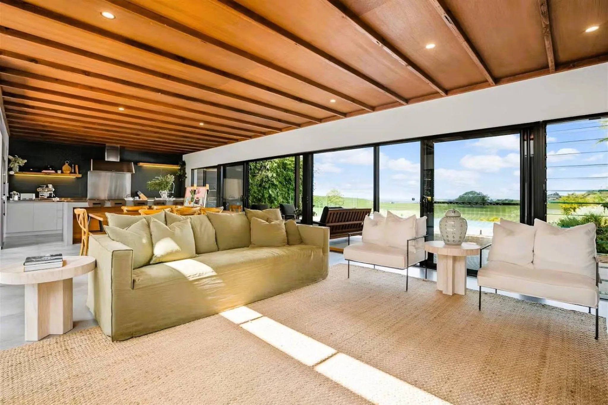 Modern living room with large windows overlooking a green landscape.
