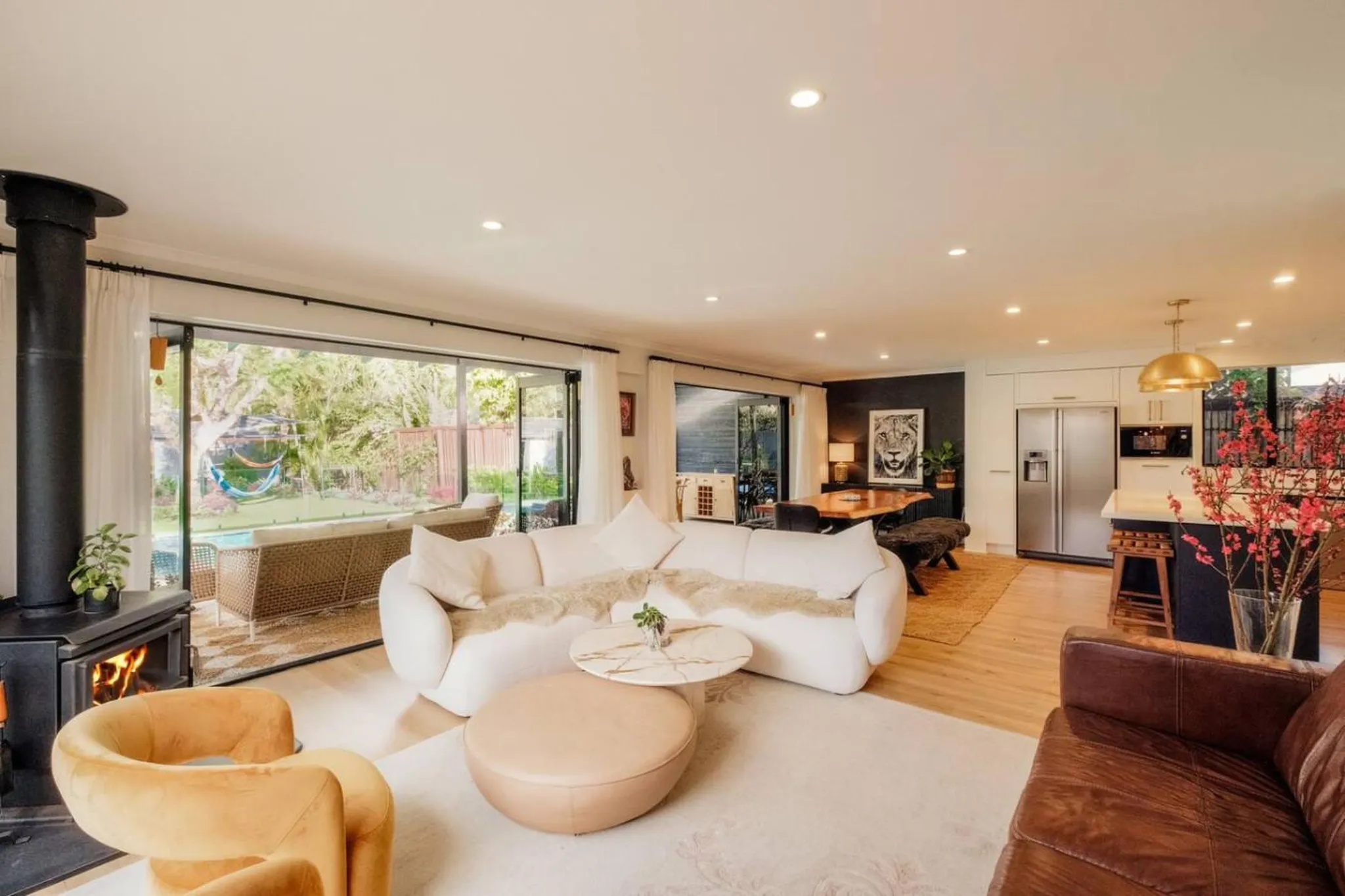Modern living room with fireplace, white sectional sofa, and kitchen island.