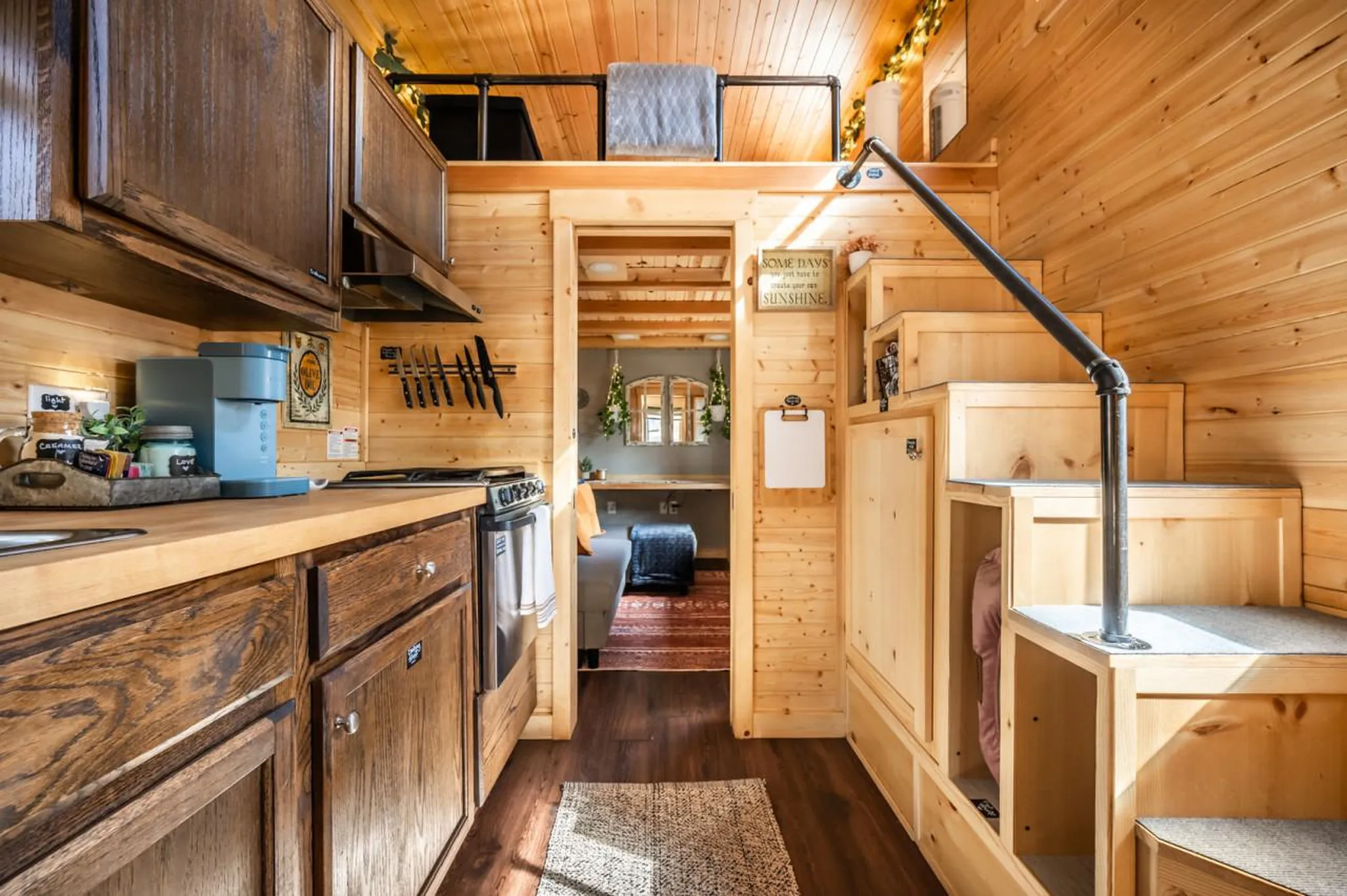 Interior view of a tiny home kitchen and stairs.