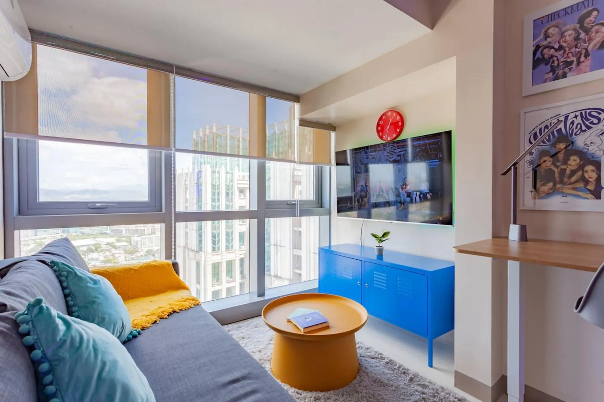 A modern living room with a grey sofa, blue cabinet, and a TV.