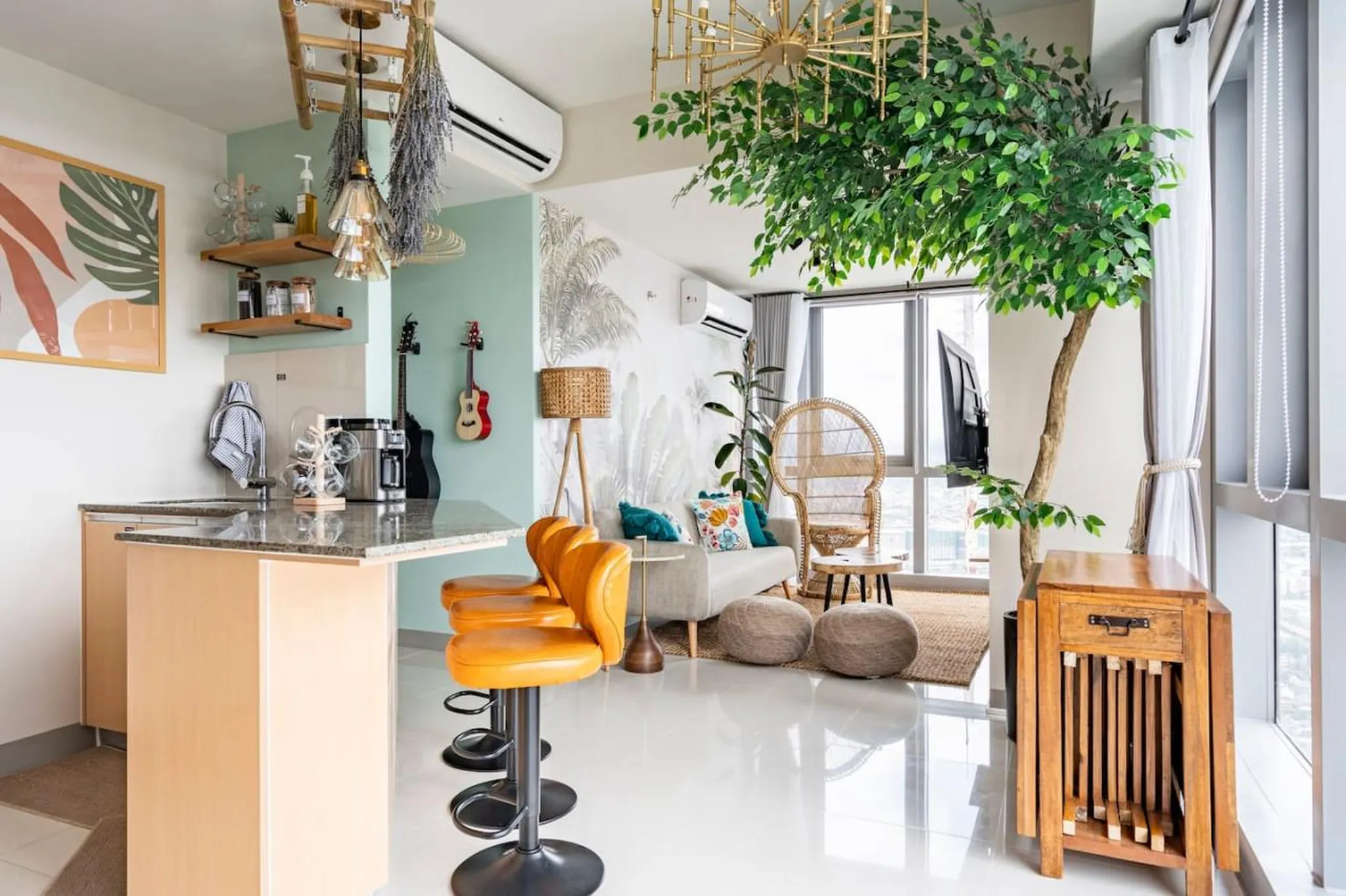 Bohemian-style living room with a large ficus tree, wicker chair, and guitars.