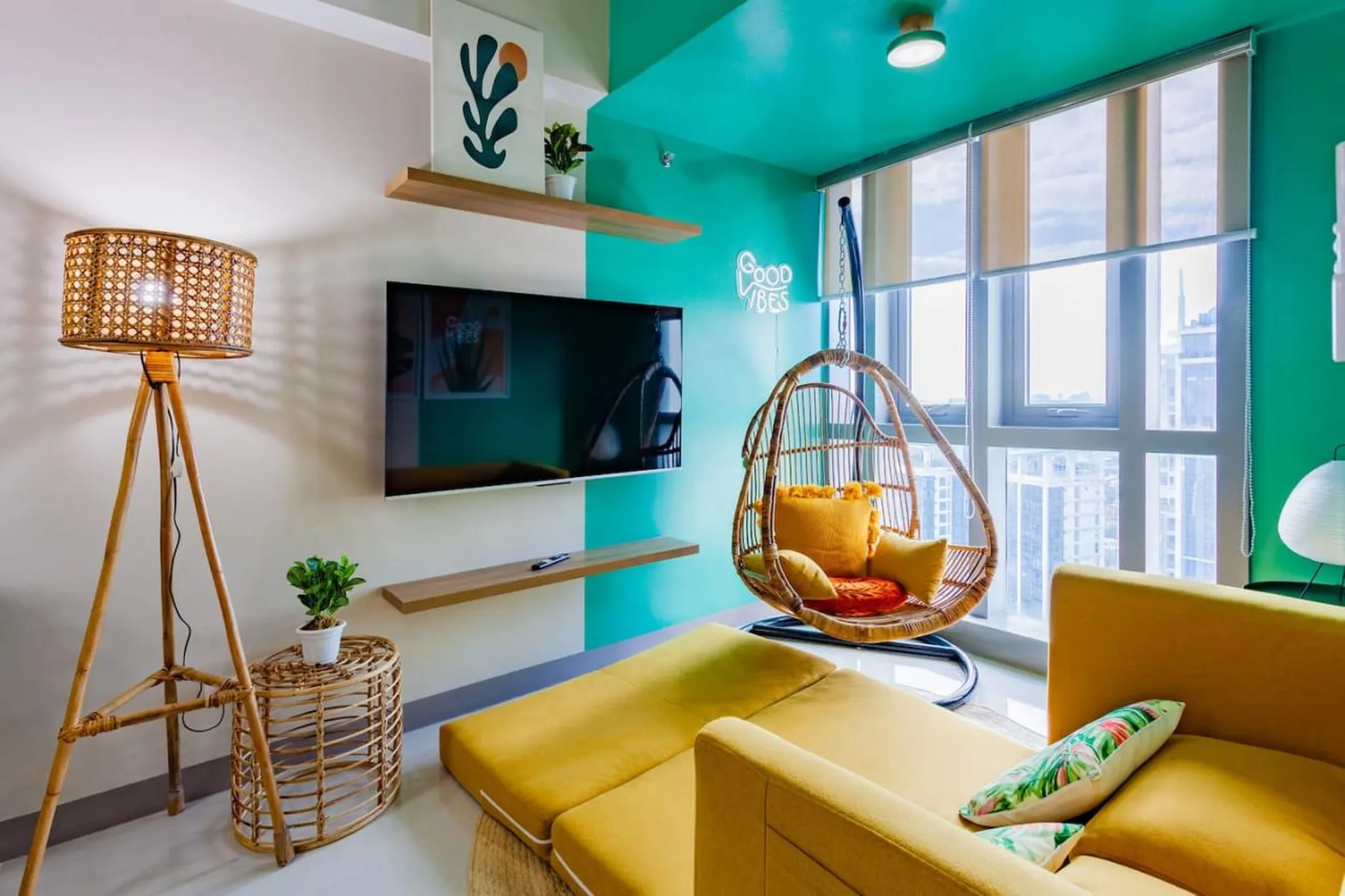 A bright living room with a yellow sofa, hanging chair, and a stylish rattan floor lamp.