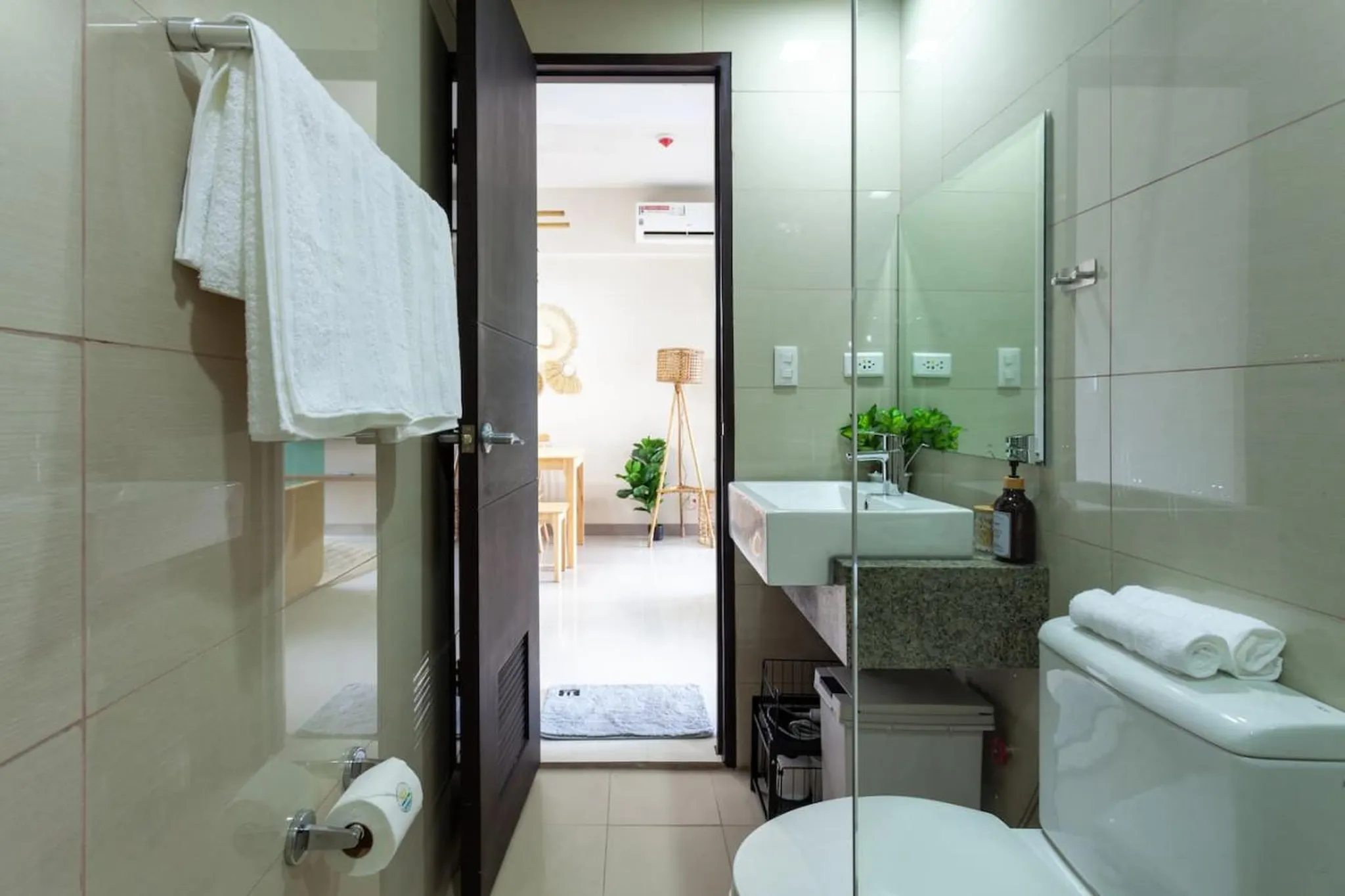 A modern bathroom with a sink, toilet, and towels.