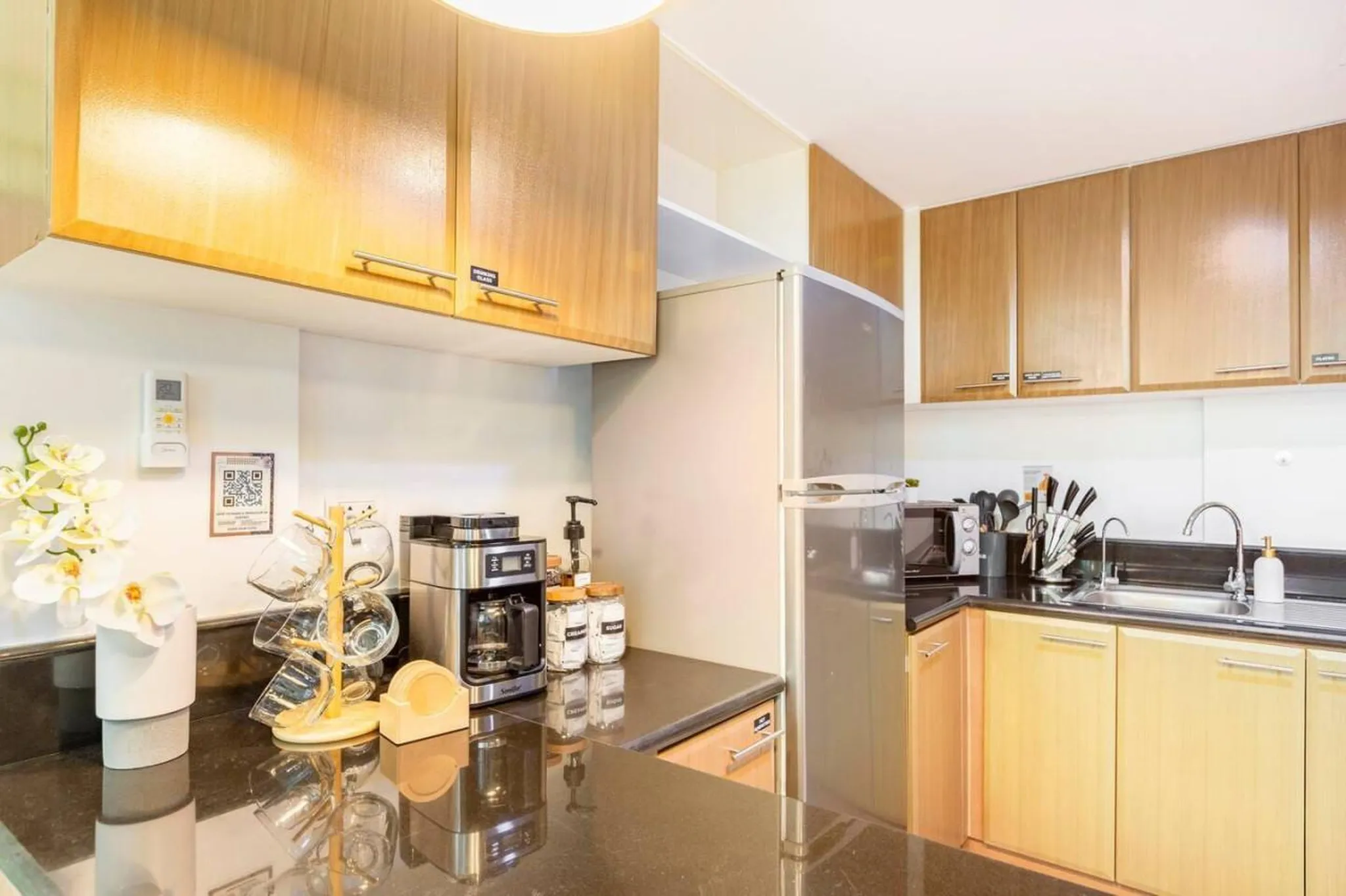 Kitchen counter with coffee maker, mugs, and a sink.