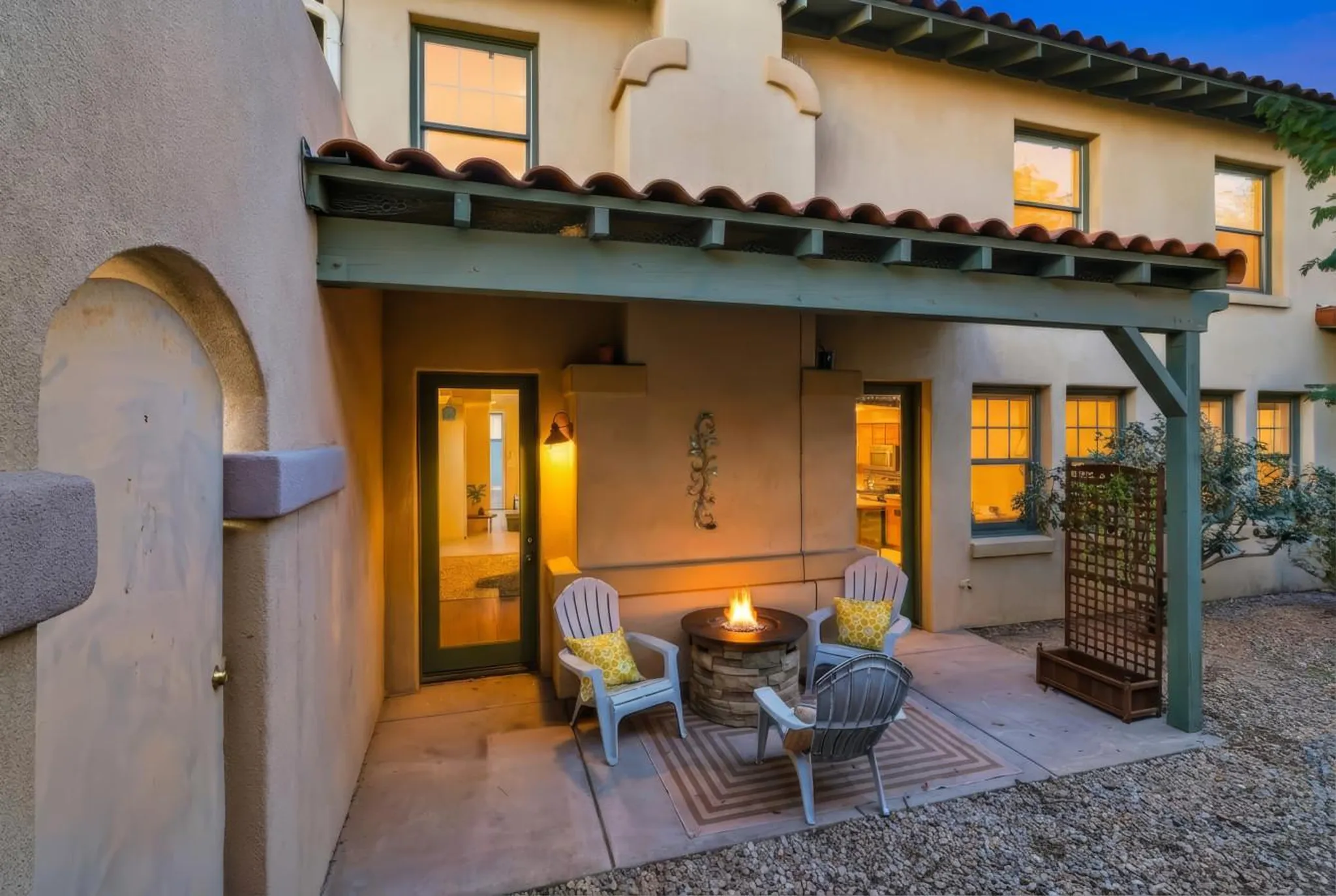 Spanish-style home with courtyard, fireplace, and seating.