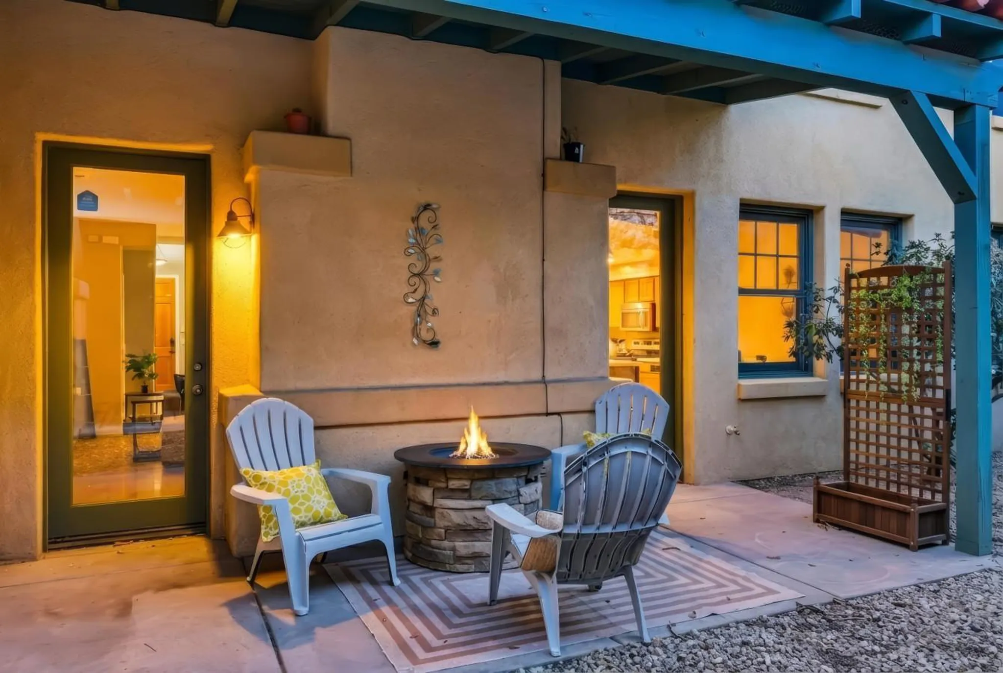 Outdoor patio with a fire pit, chairs, and a lattice planter.