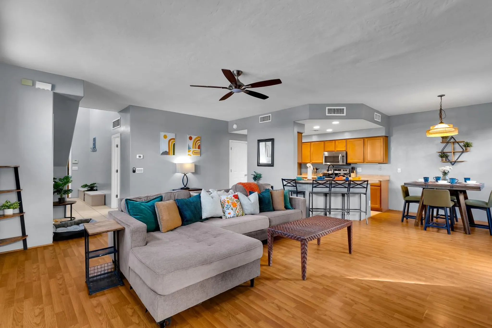 Living room and kitchen with sectional sofa, coffee table, island with bar stools, and dining table.