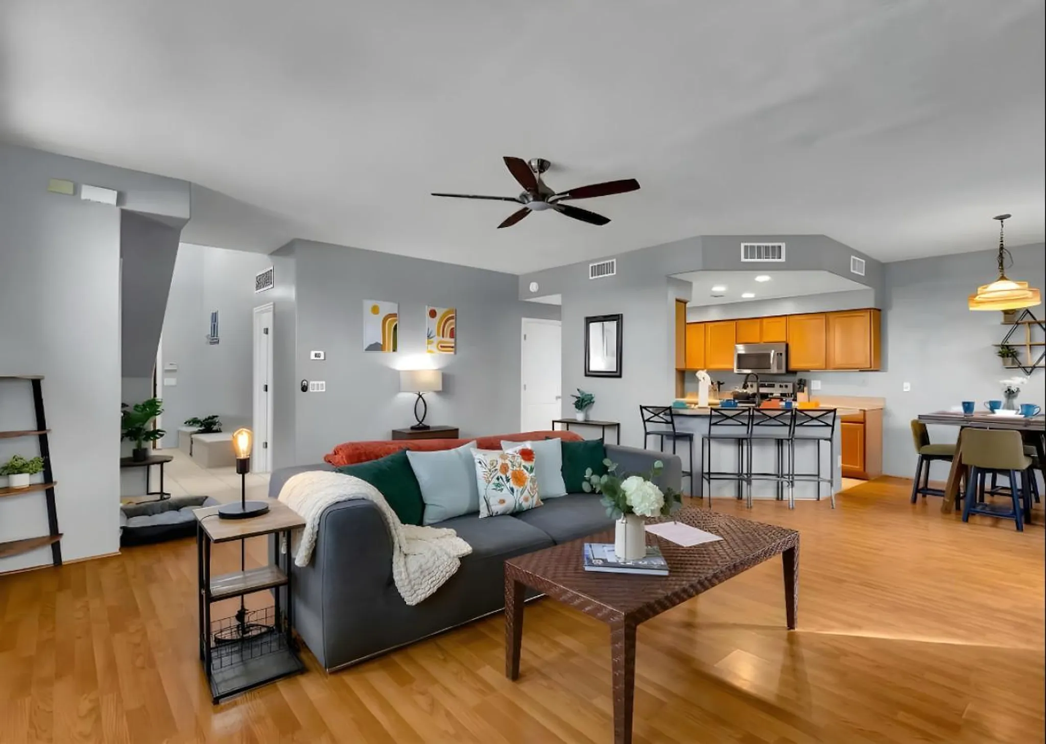 Living room with a gray sofa, coffee table, kitchen island, and dining area.
