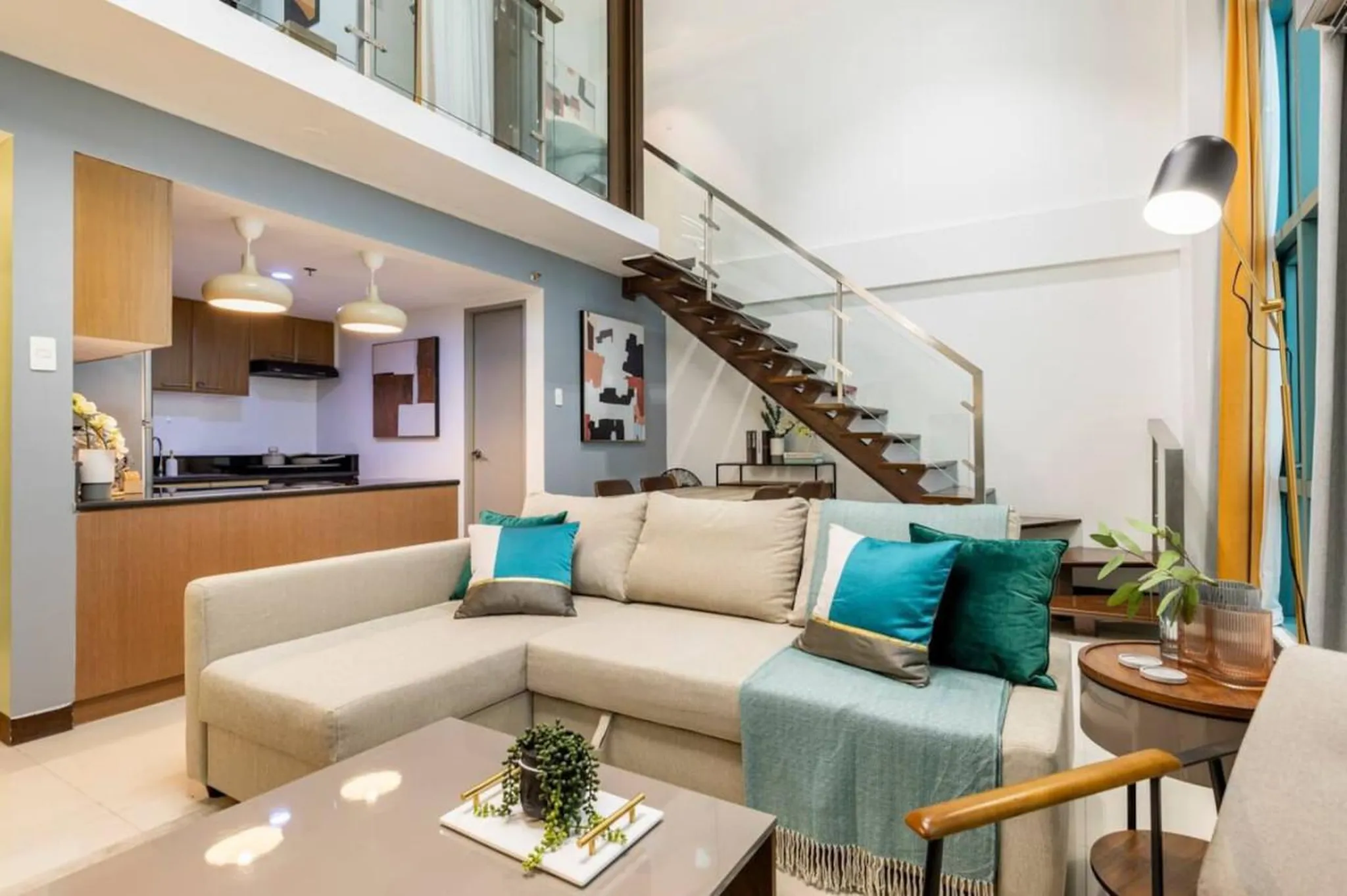 Interior of a modern living room with a sectional sofa and staircase.