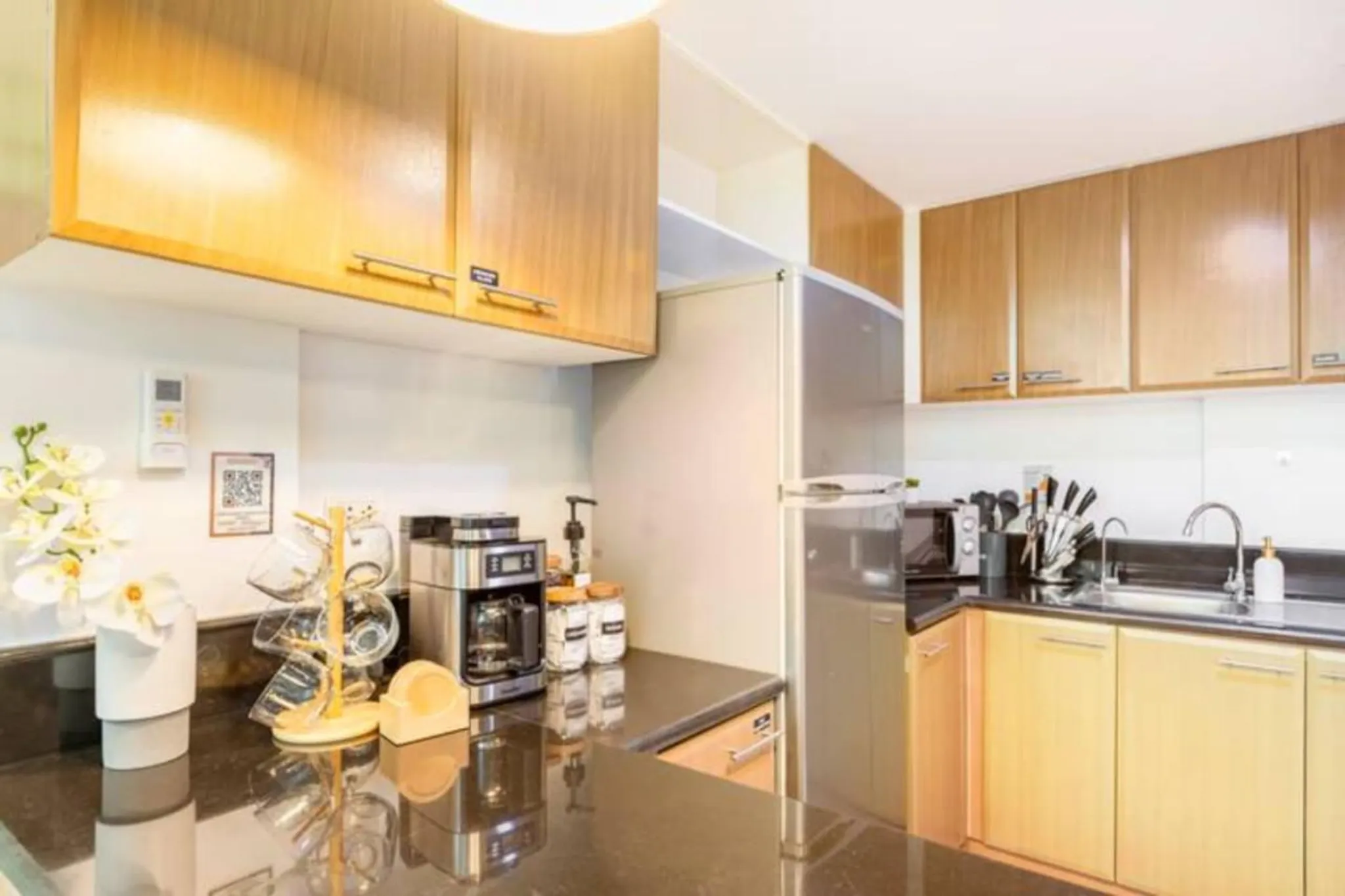 kitchen with a stainless steel refrigerator, espresso machine, and cabinets.