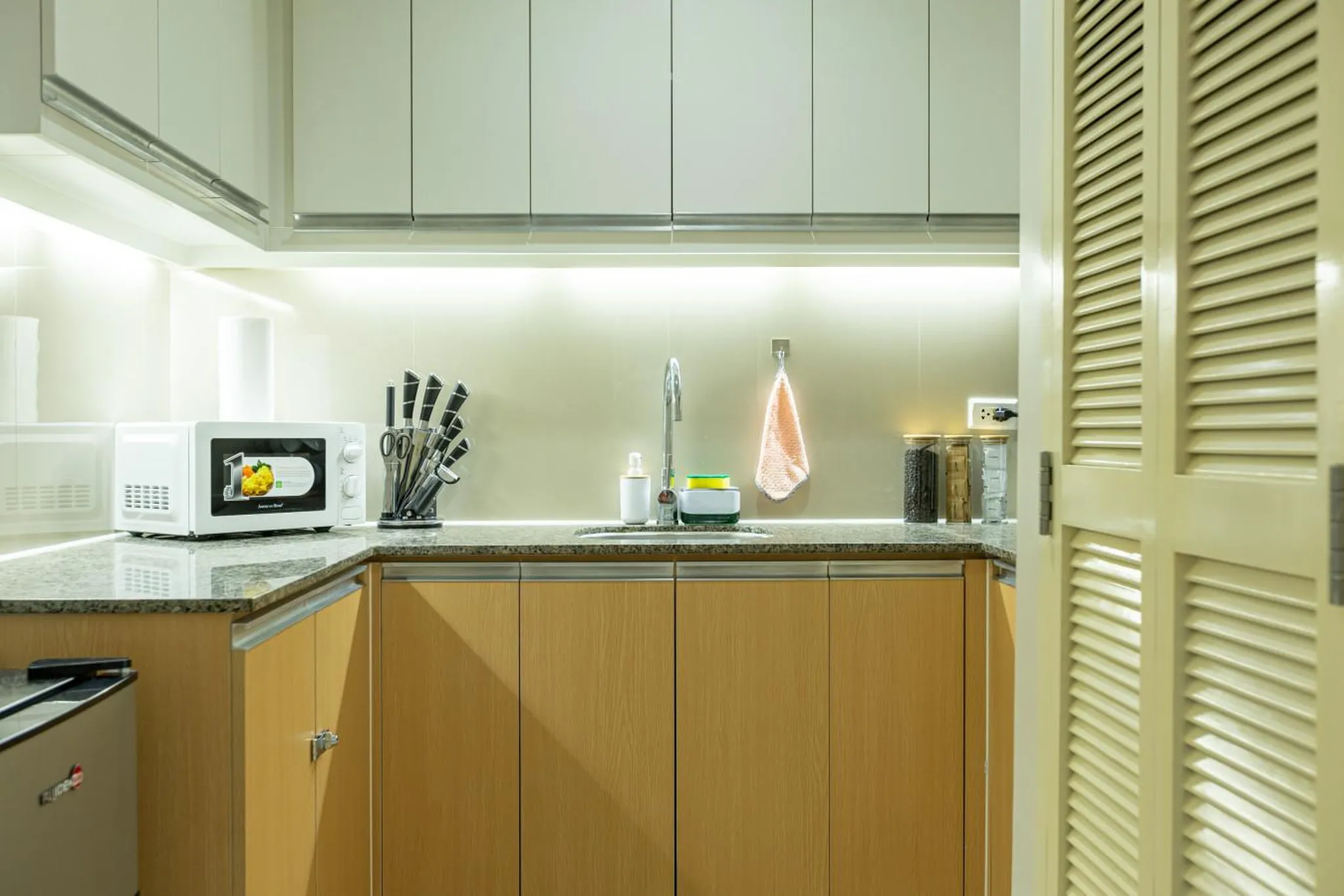 A modern kitchen with wooden cabinets and a granite countertop.