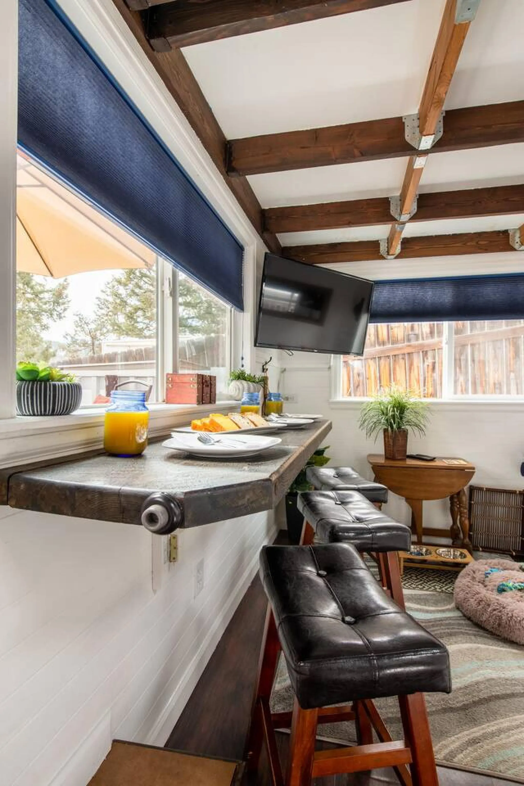 A modern bar with stools and a television mounted on the wall.