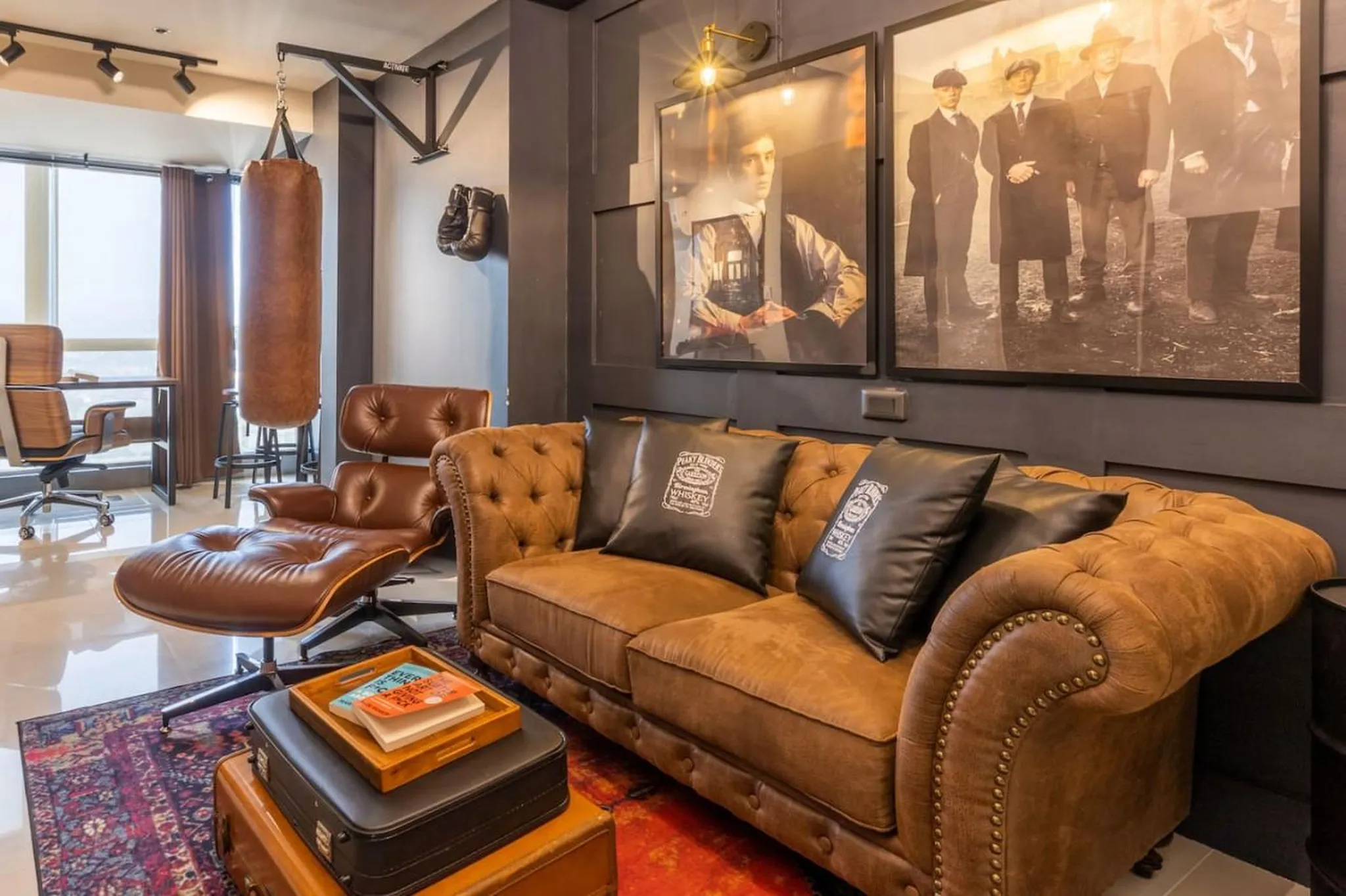 A brown leather couch with black pillows in a modern living room.