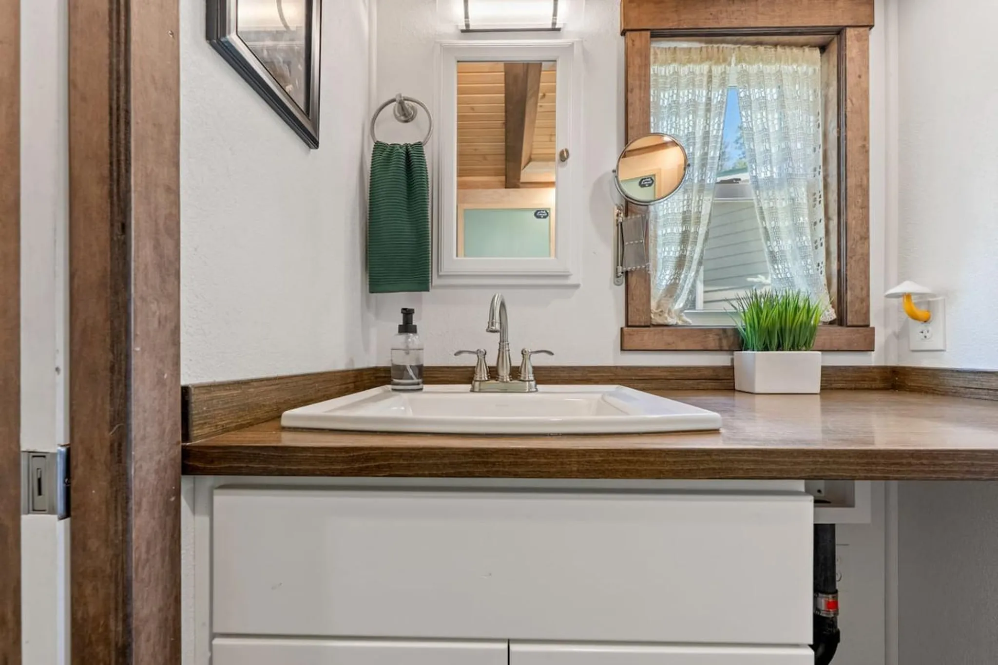 A bathroom vanity with a white sink, chrome faucet, and a wooden countertop.