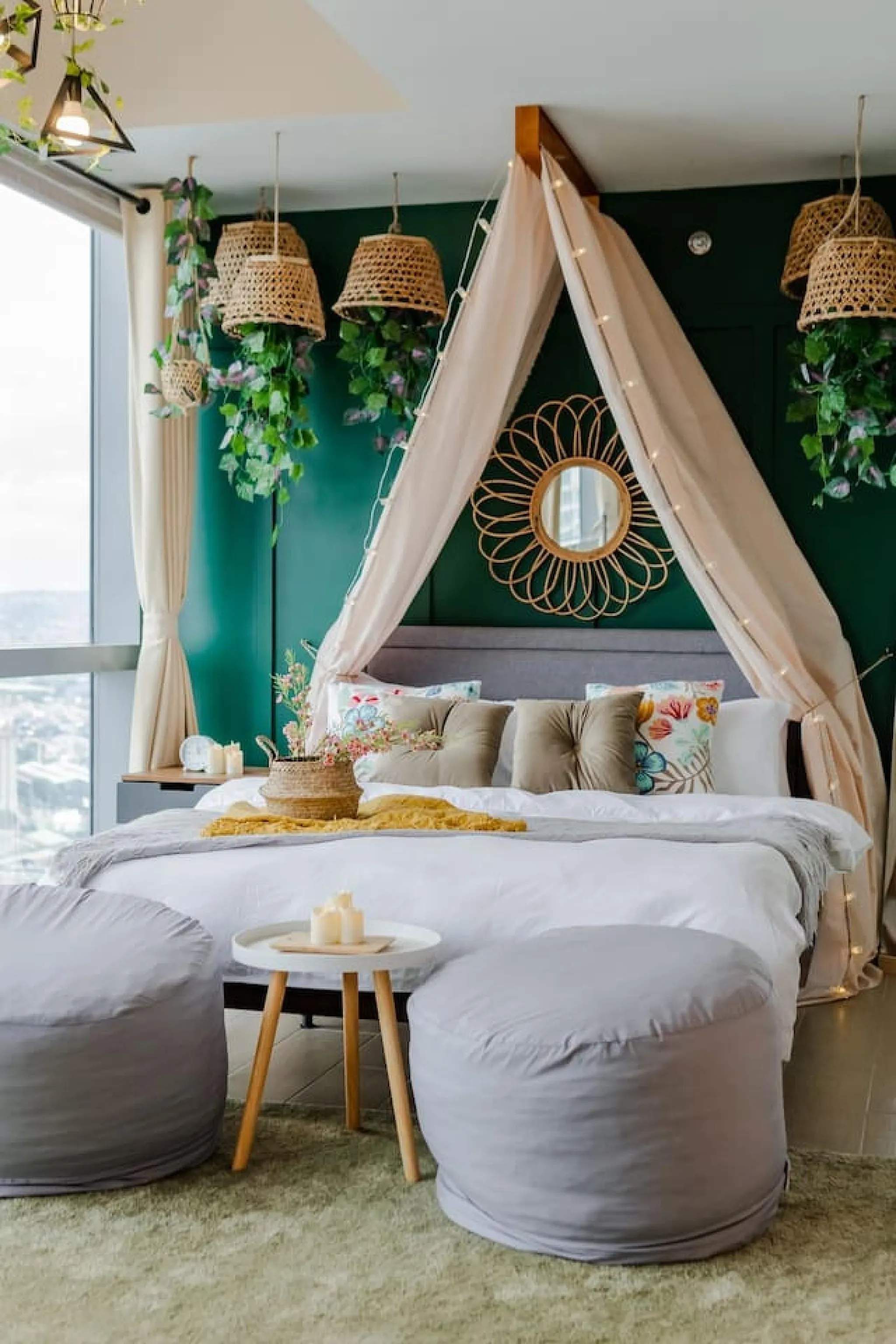 A bedroom with a canopied bed, hanging plants, and rattan light fixtures.