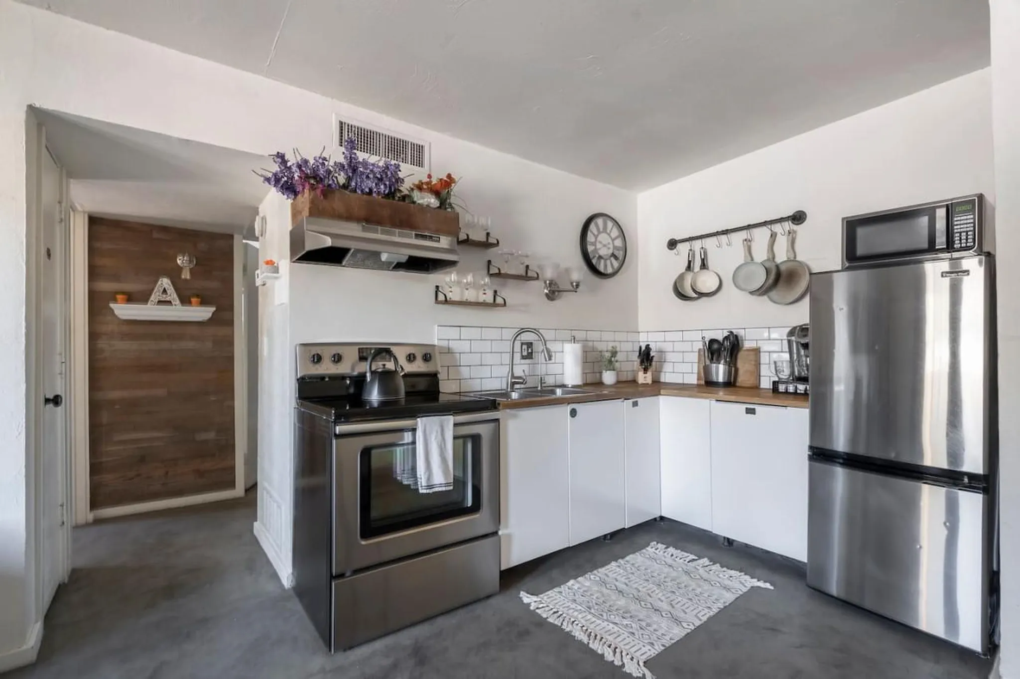 A modern kitchen with stainless steel appliances and white cabinets.