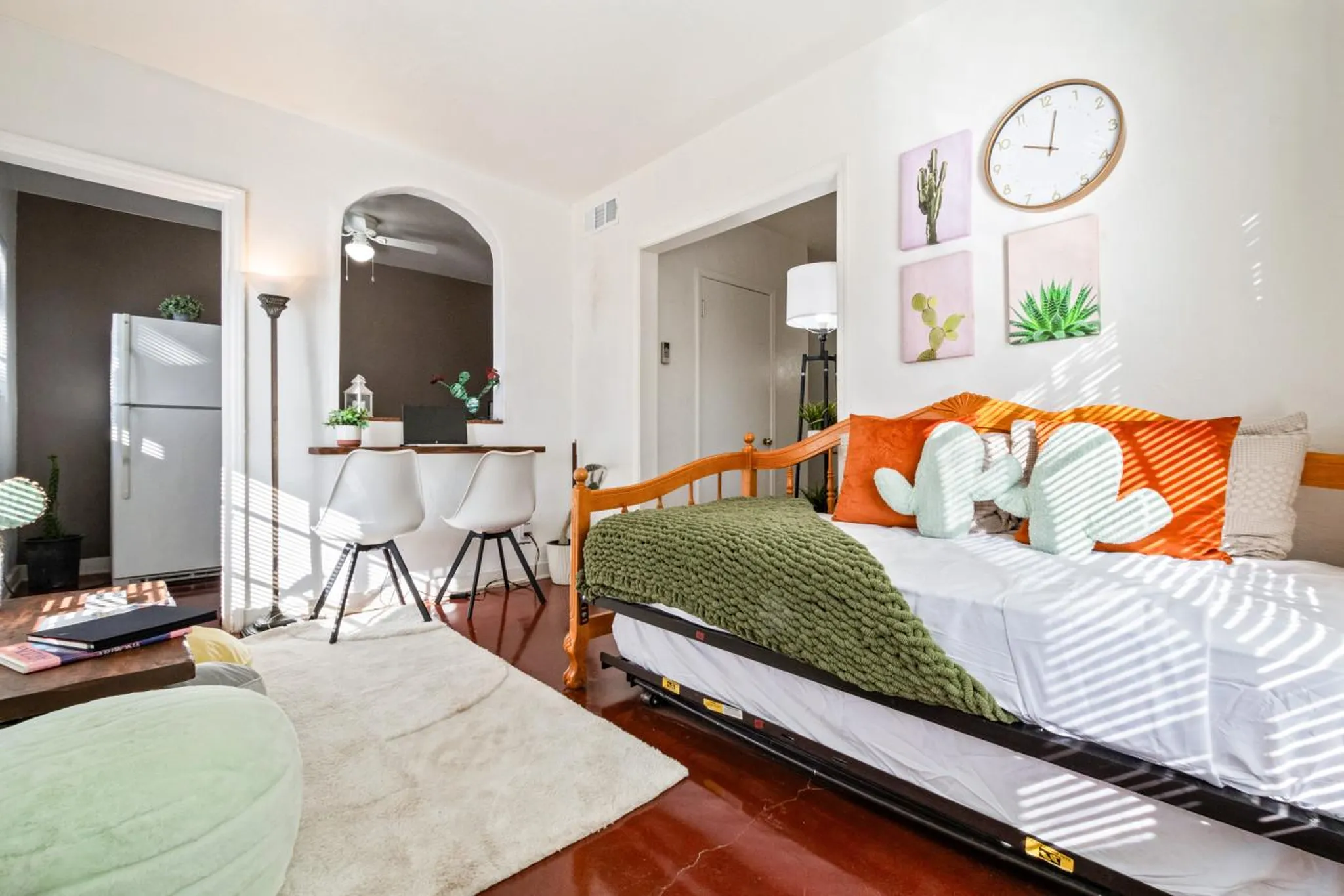 A bedroom with a daybed, two chairs, and a desk.