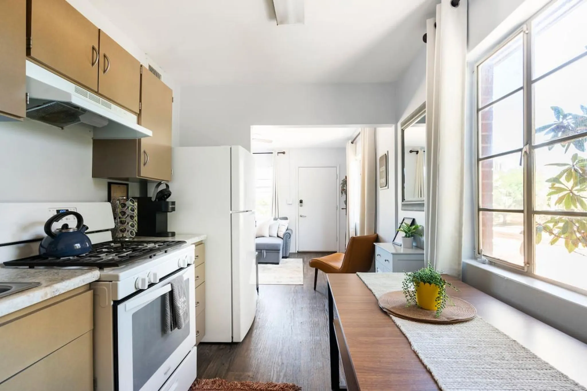 A bright, open-plan studio apartment with a modern kitchen and dining area.