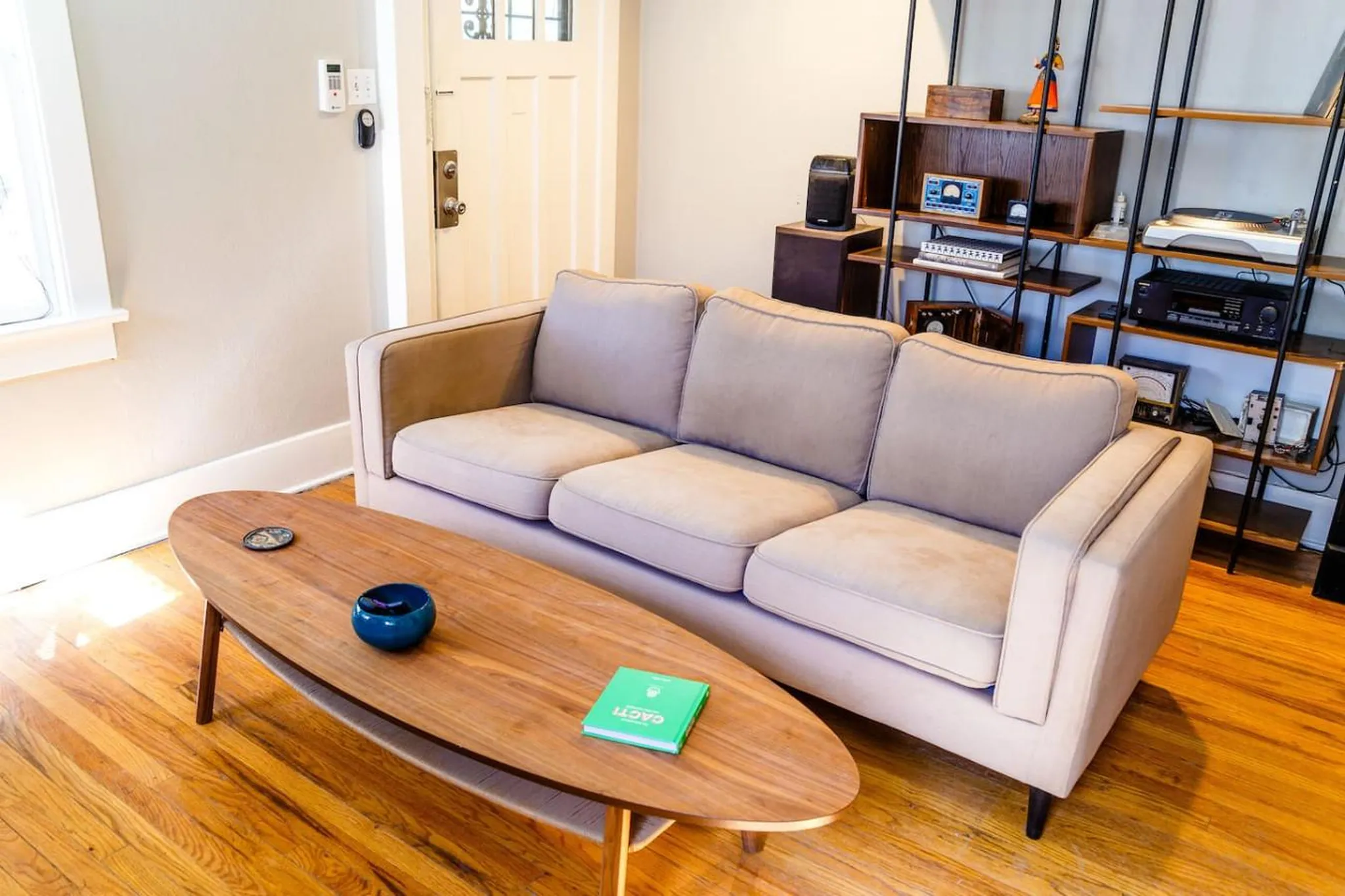 A light tan sofa with a wooden coffee table in a living room.
