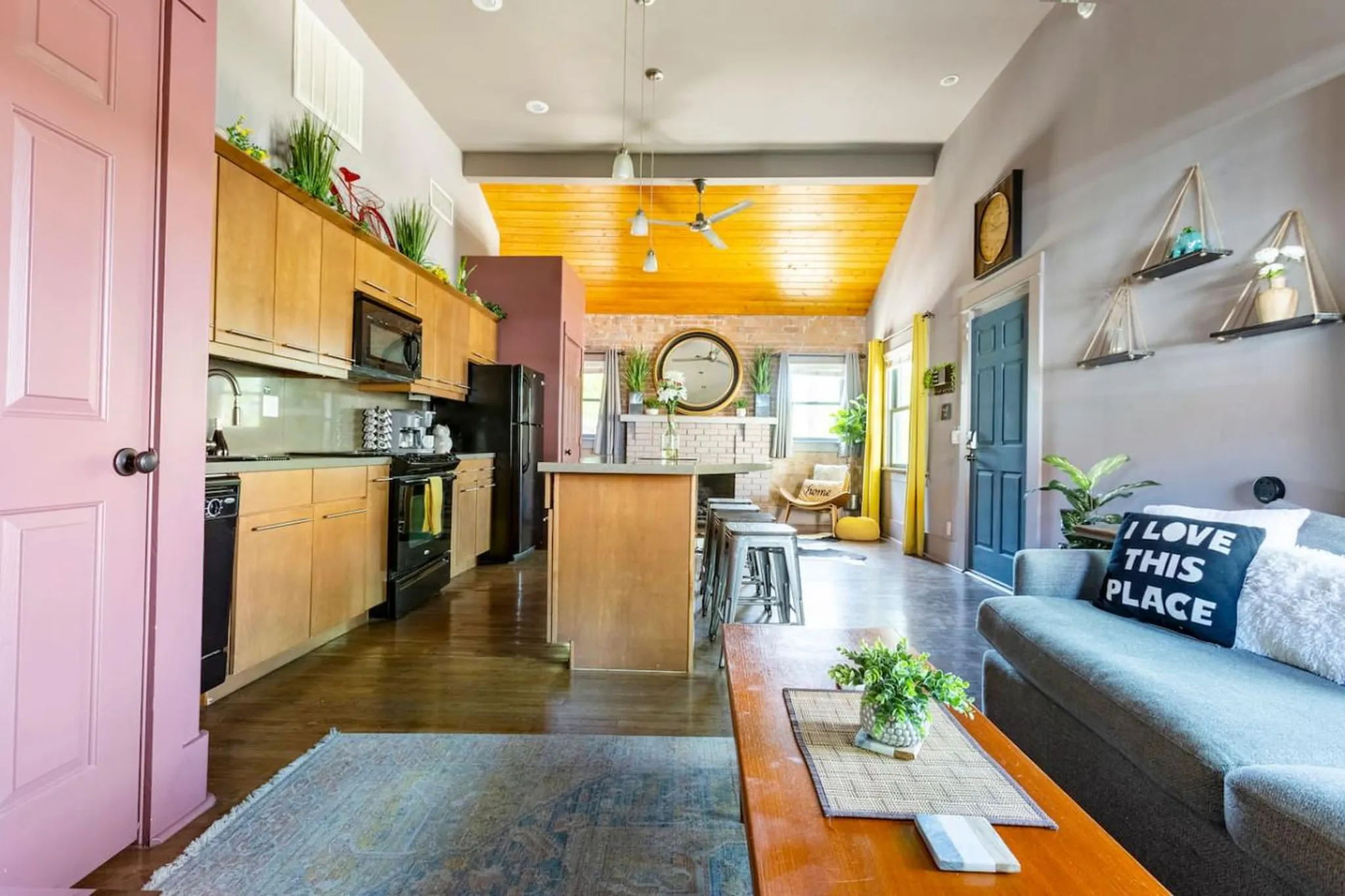 Living room and kitchen area with stylish furniture and decor.