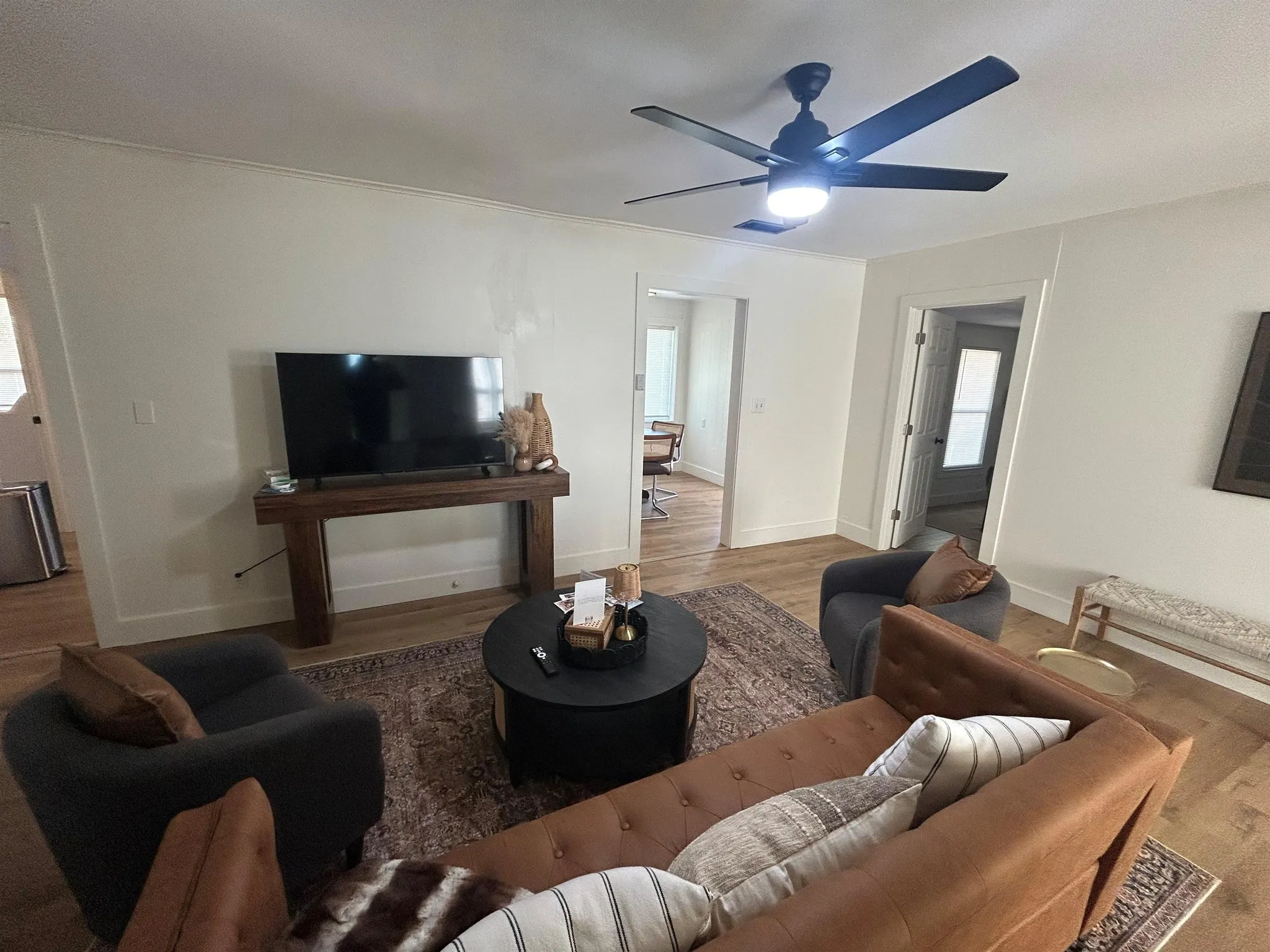 Living room with a couch, armchair, coffee table, and TV.