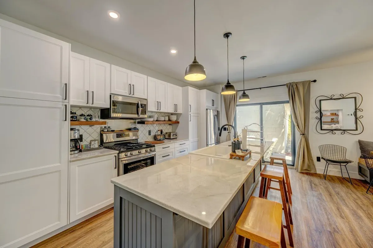 White kitchen with a large island at The Pearl of Sheridan, a Wyo Stays home