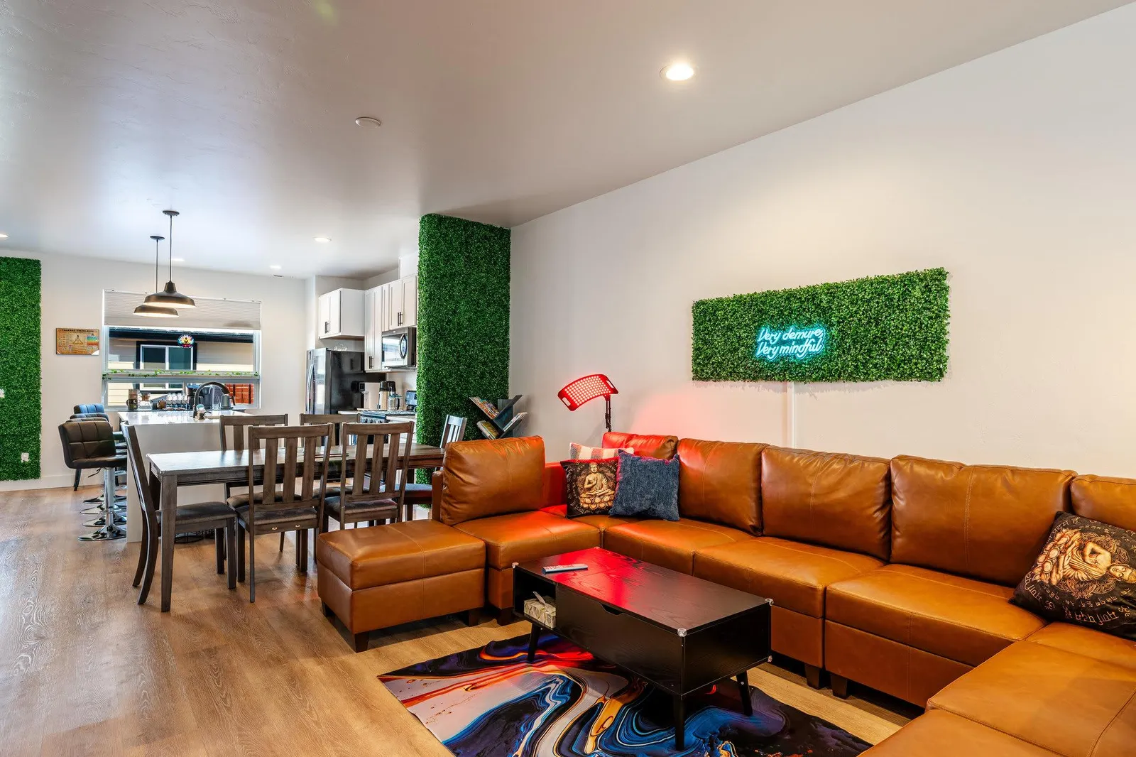 Living room with leather sectional and open kitchen beyond at The Zen Den