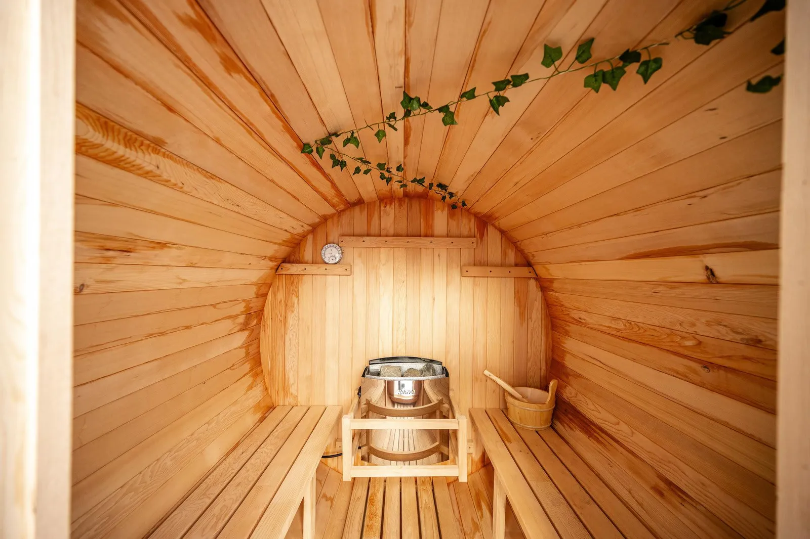 Inside the cedar barrel sauna at The Zen Den, with heater and thermometer