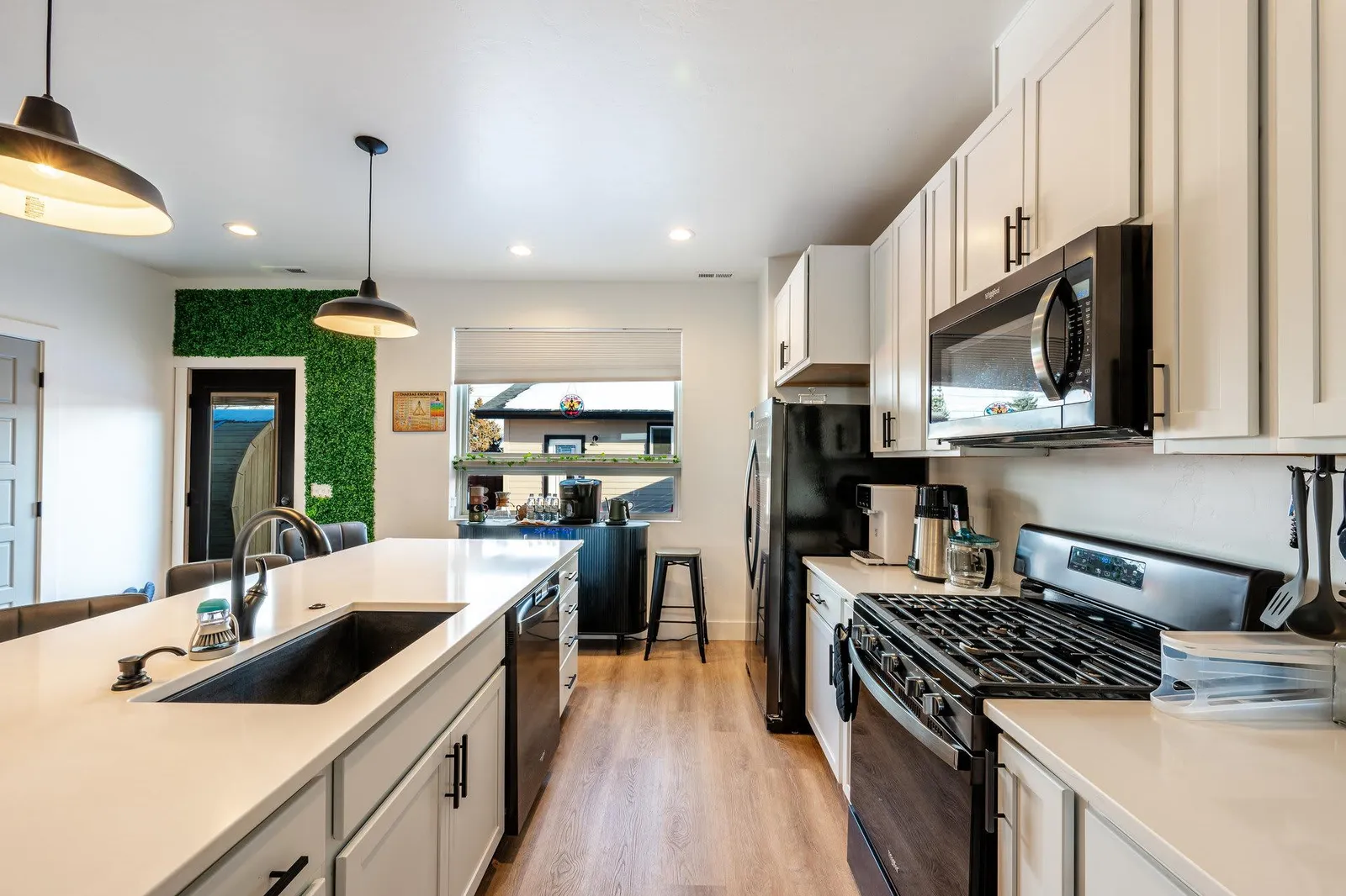 Fully stocked open kitchen at The Zen Den with white cabinetry and stainless appliances