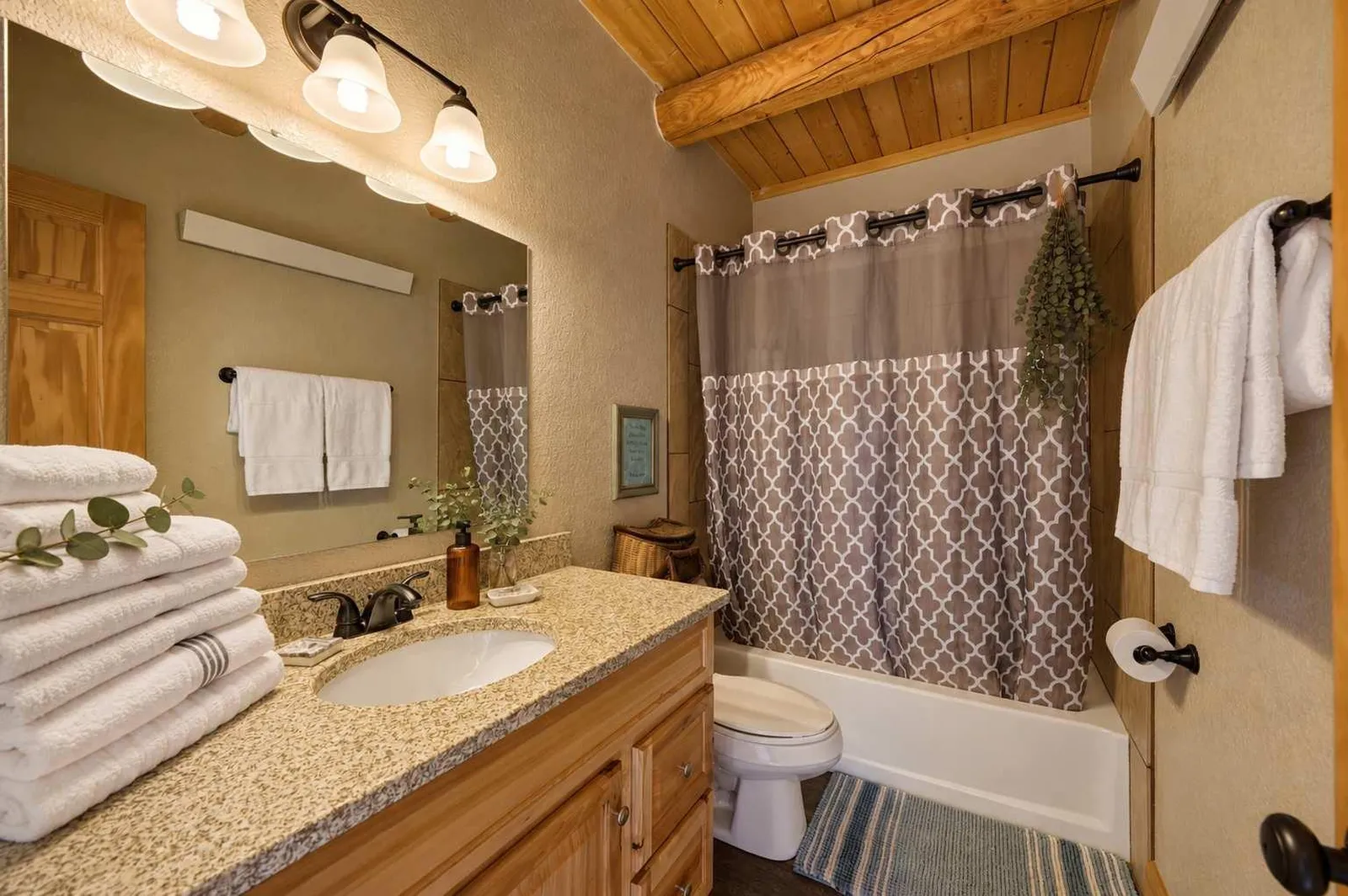Full bathroom at Piton cabin with a walk-in shower, wood ceiling, and granite counter — no bathtub