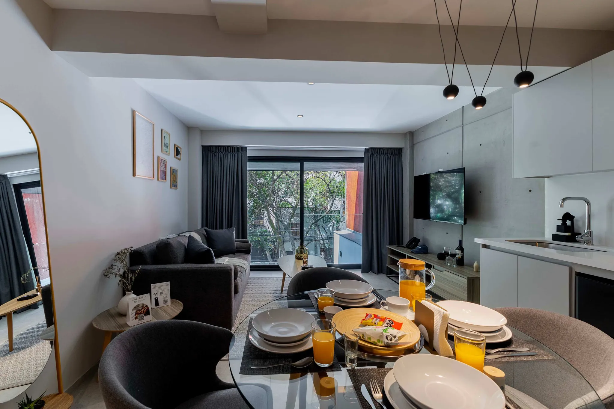 A dining table is set with plates, glasses of orange juice, and snacks.