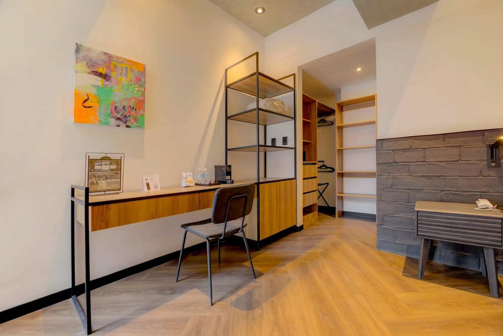 A modern room with a desk, chair, and open closet.
