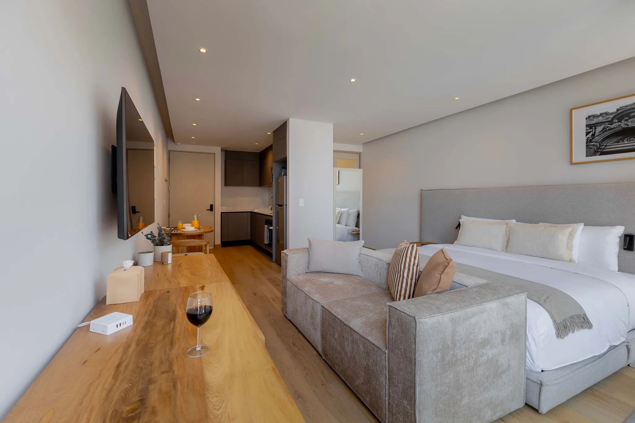 A spacious studio apartment with a bed, couch, kitchen, and dining area.