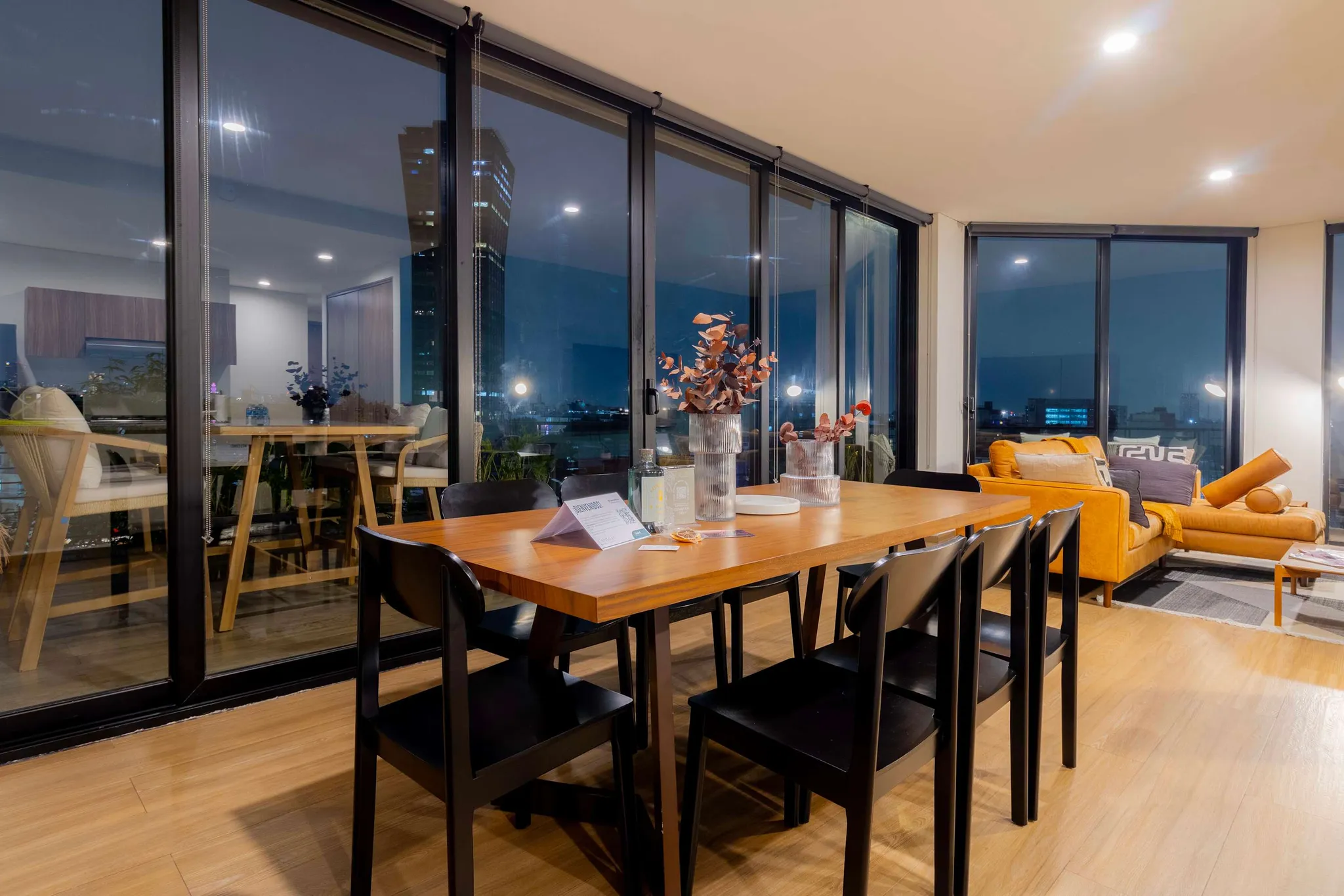 A dining table and chairs with a city view.