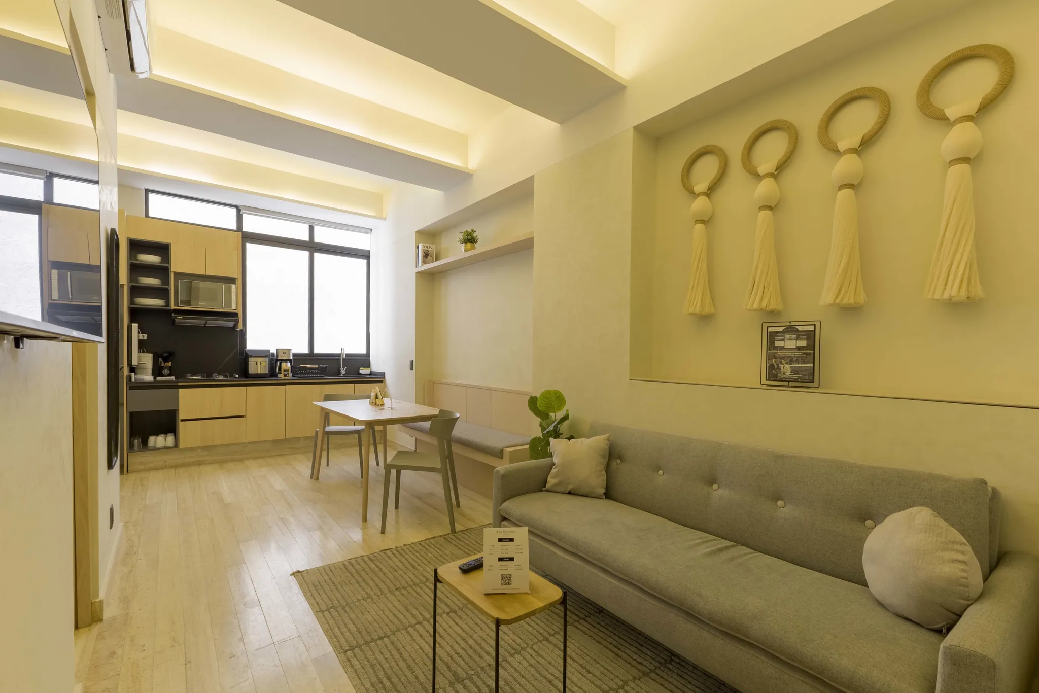 A stylish living room with a modern kitchen, dining area, and comfortable seating.
