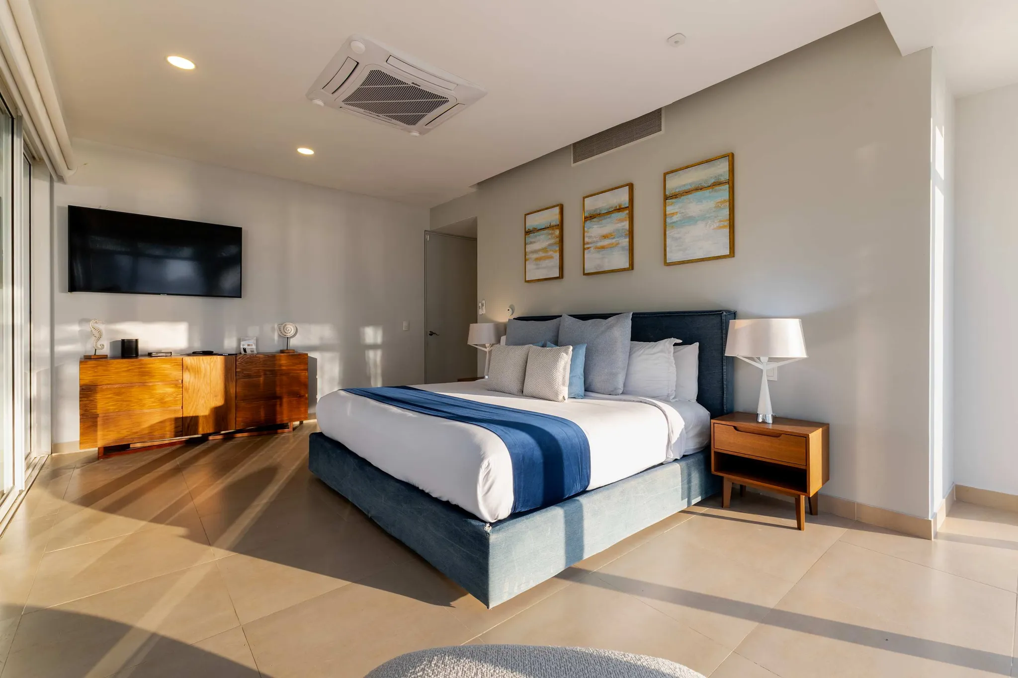 A modern bedroom with a king-size bed, nightstands, and a television.