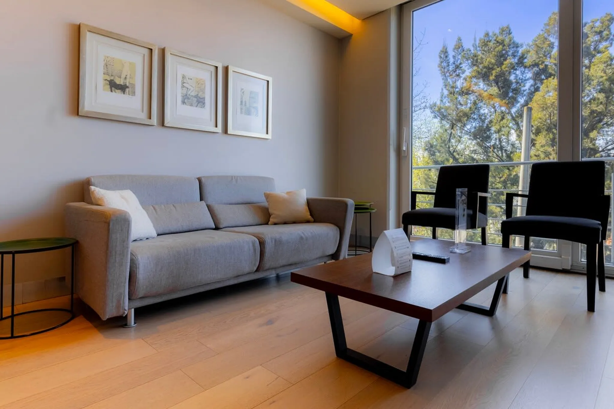 Living room with sofa, coffee table and two black chairs.