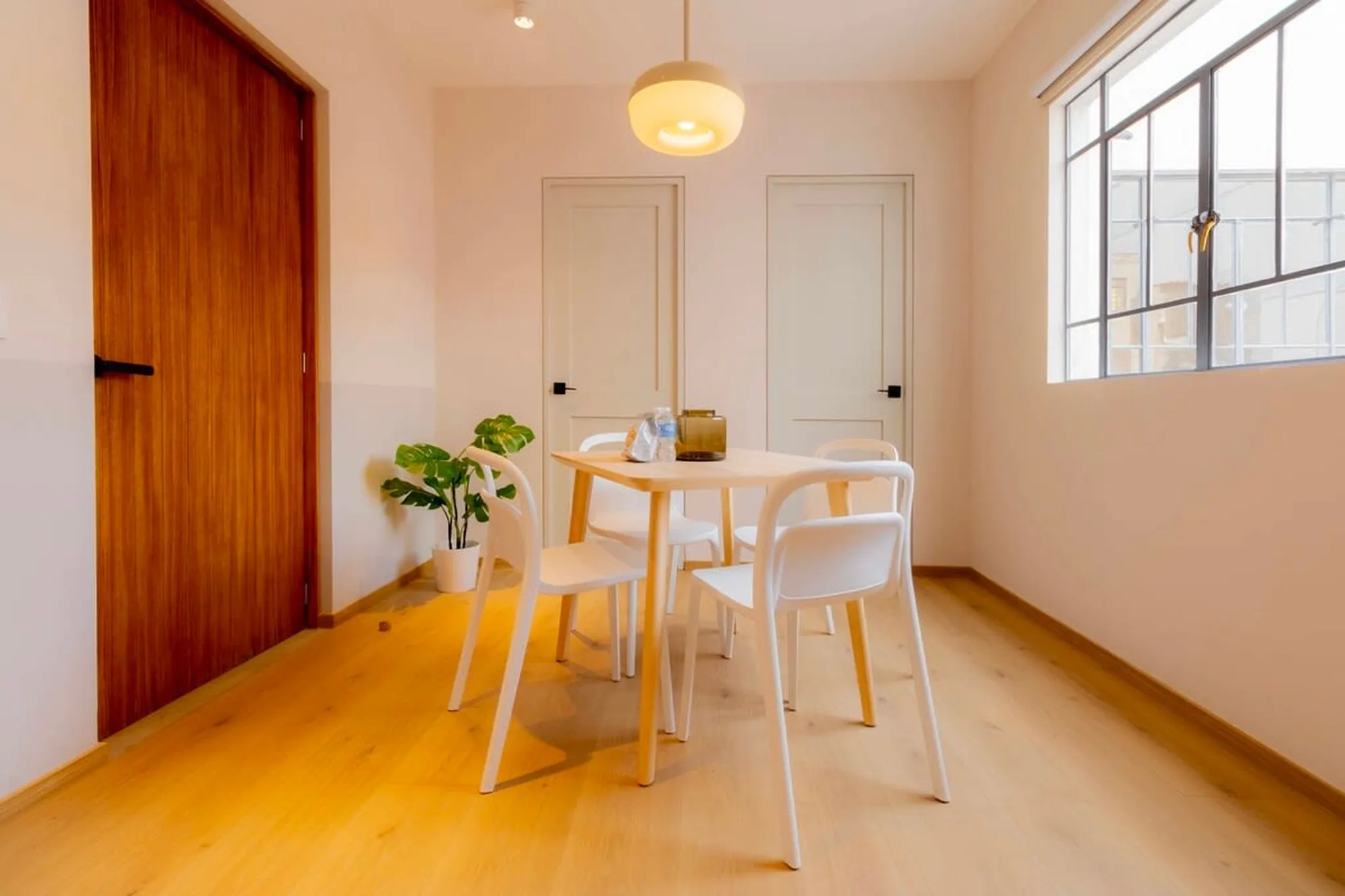 A dining area with a wooden table and four white chairs.