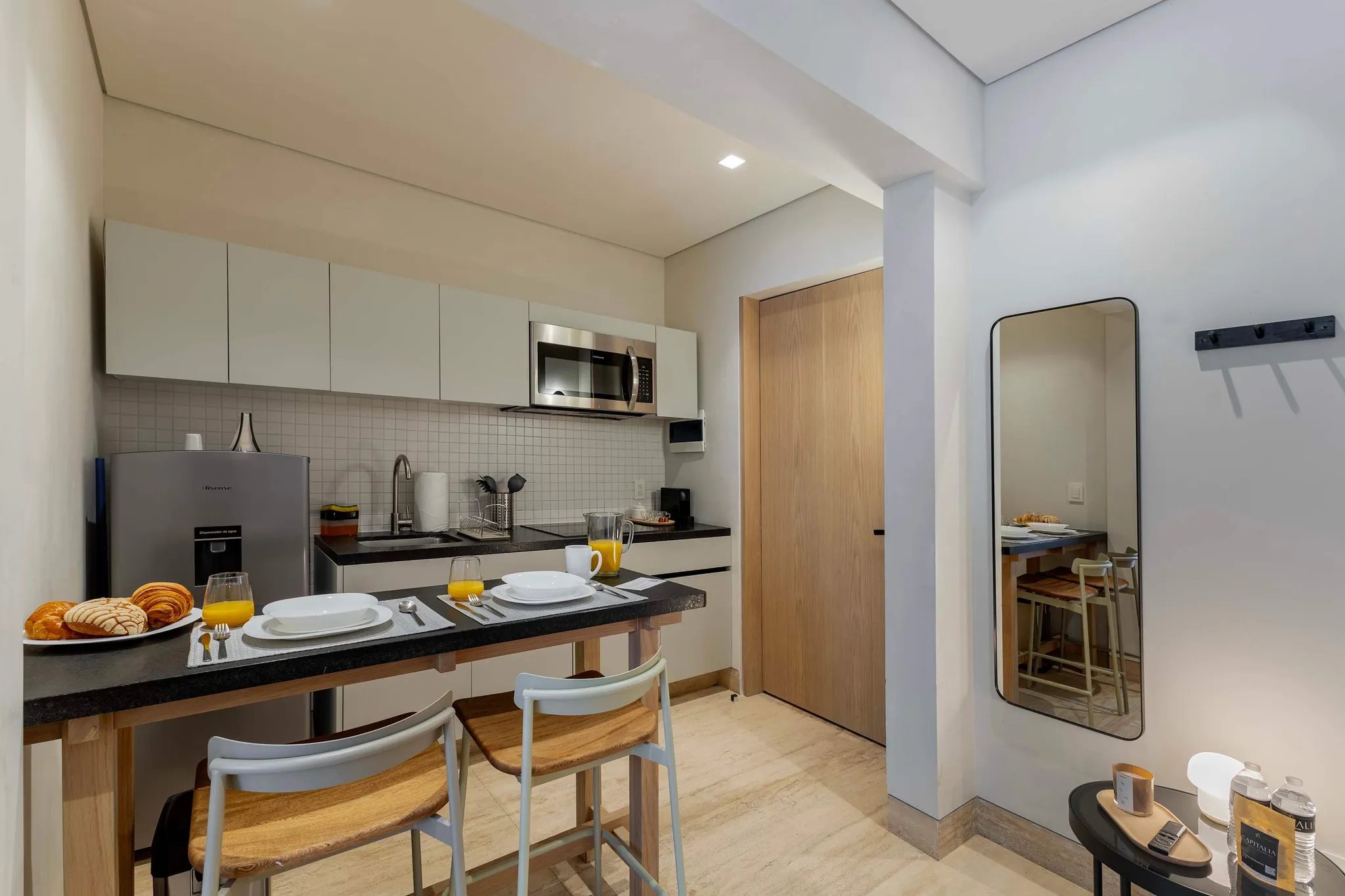 A breakfast bar with pastries and juice is set up in a kitchen.