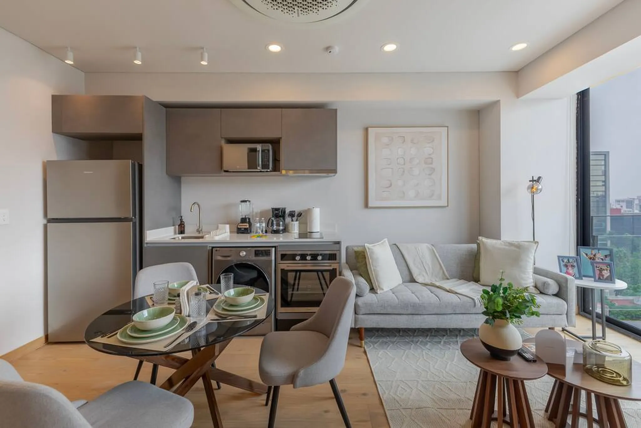 A modern studio apartment with a kitchen, dining table, and living area.