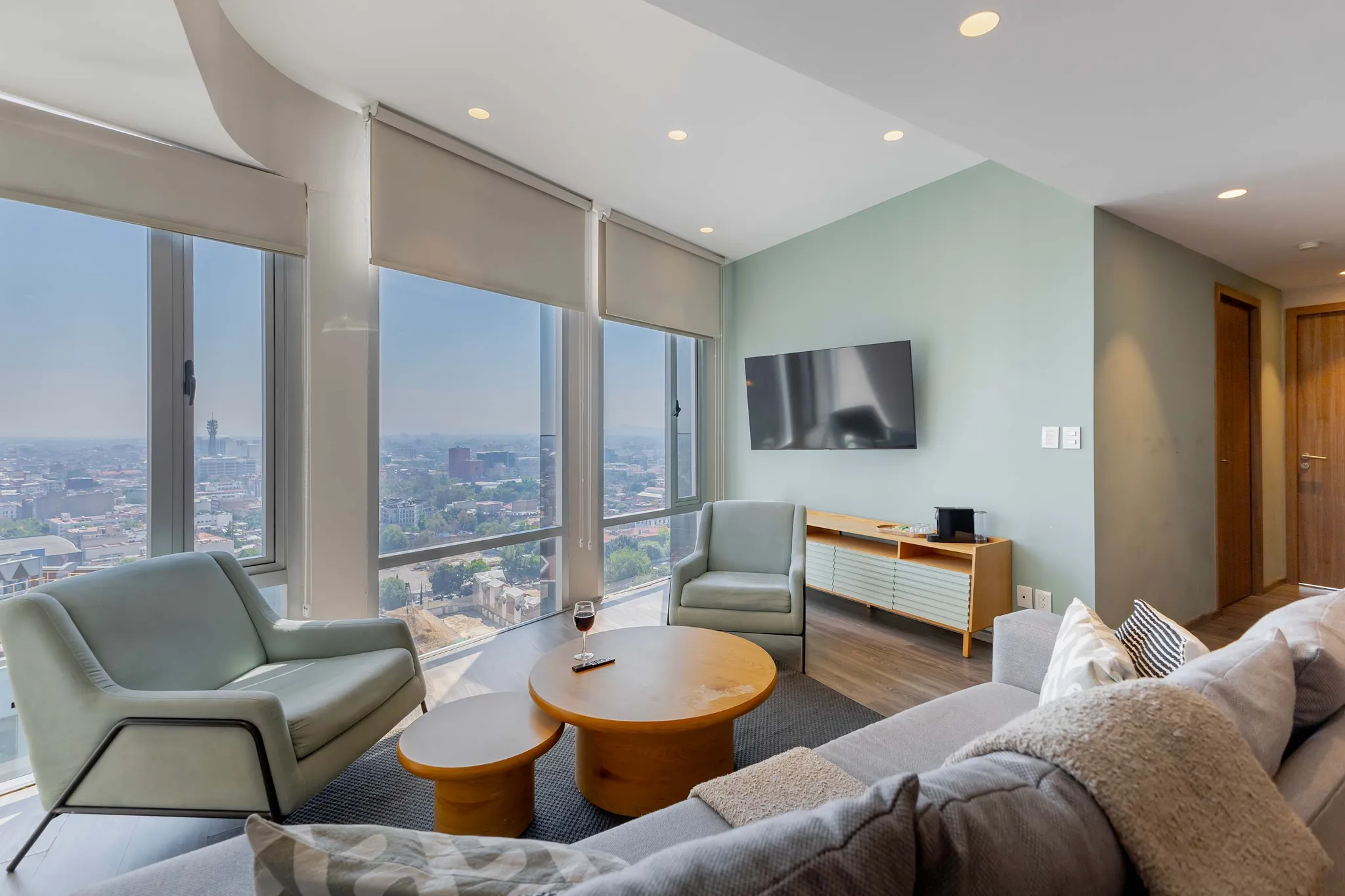 Modern living room with city views, plush sofas, and a minimalist coffee table.